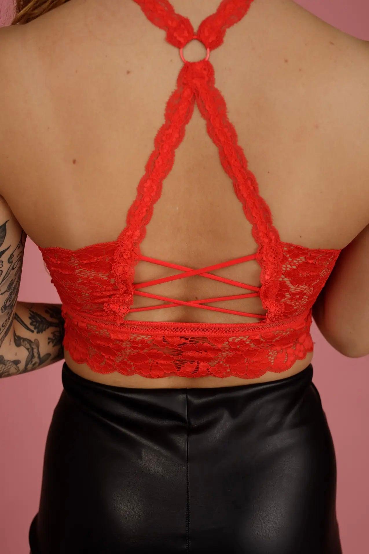 Back view of red lace bralette with scalloped edges and crisscross straps paired with black faux leather bottoms