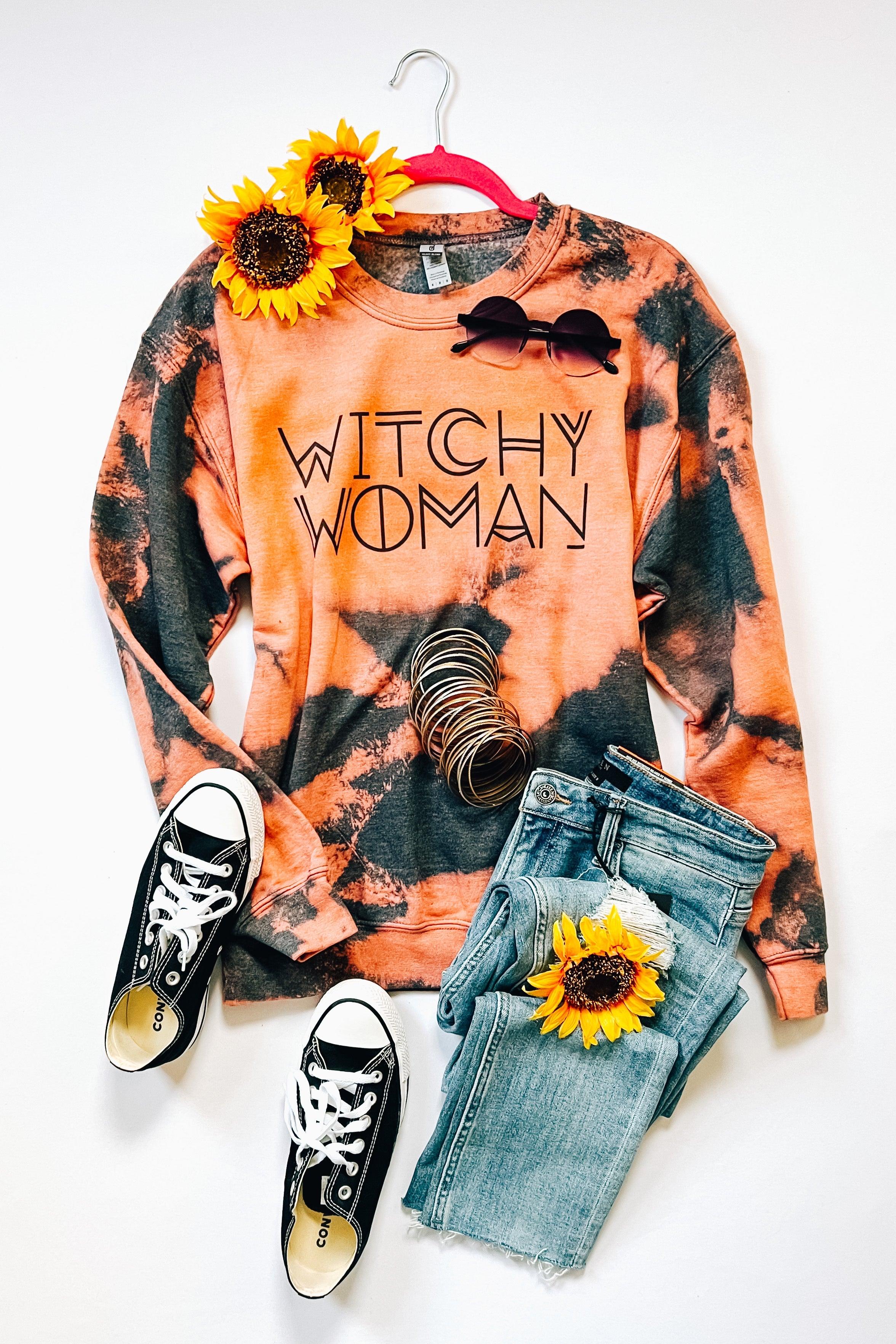 Charcoal and pink bleached sweatshirt with "Witchy Woman" text styled with denim jeans, sneakers, sunglasses, bracelets, and sunflowers