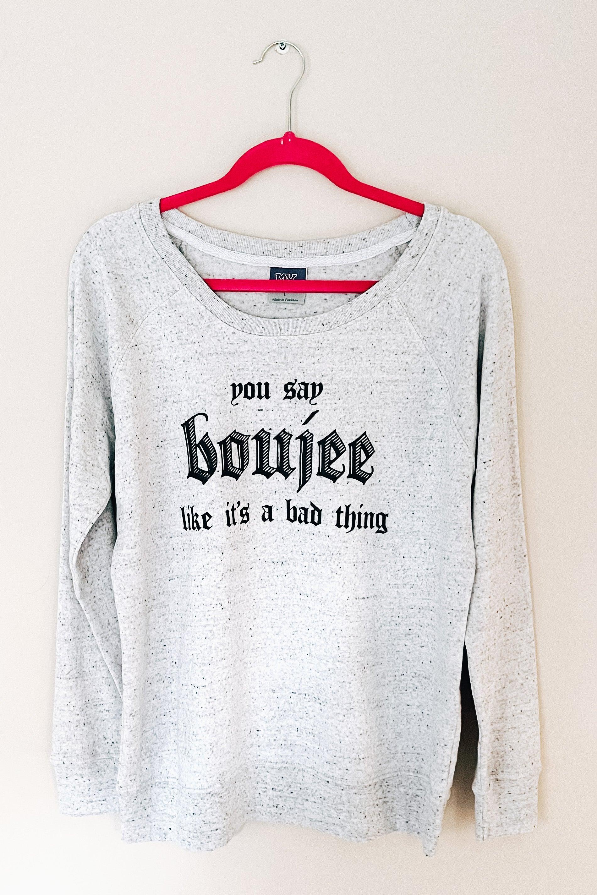 Grey speckled pullover with bold black text reading "you say boujee like it’s a bad thing" on red hanger