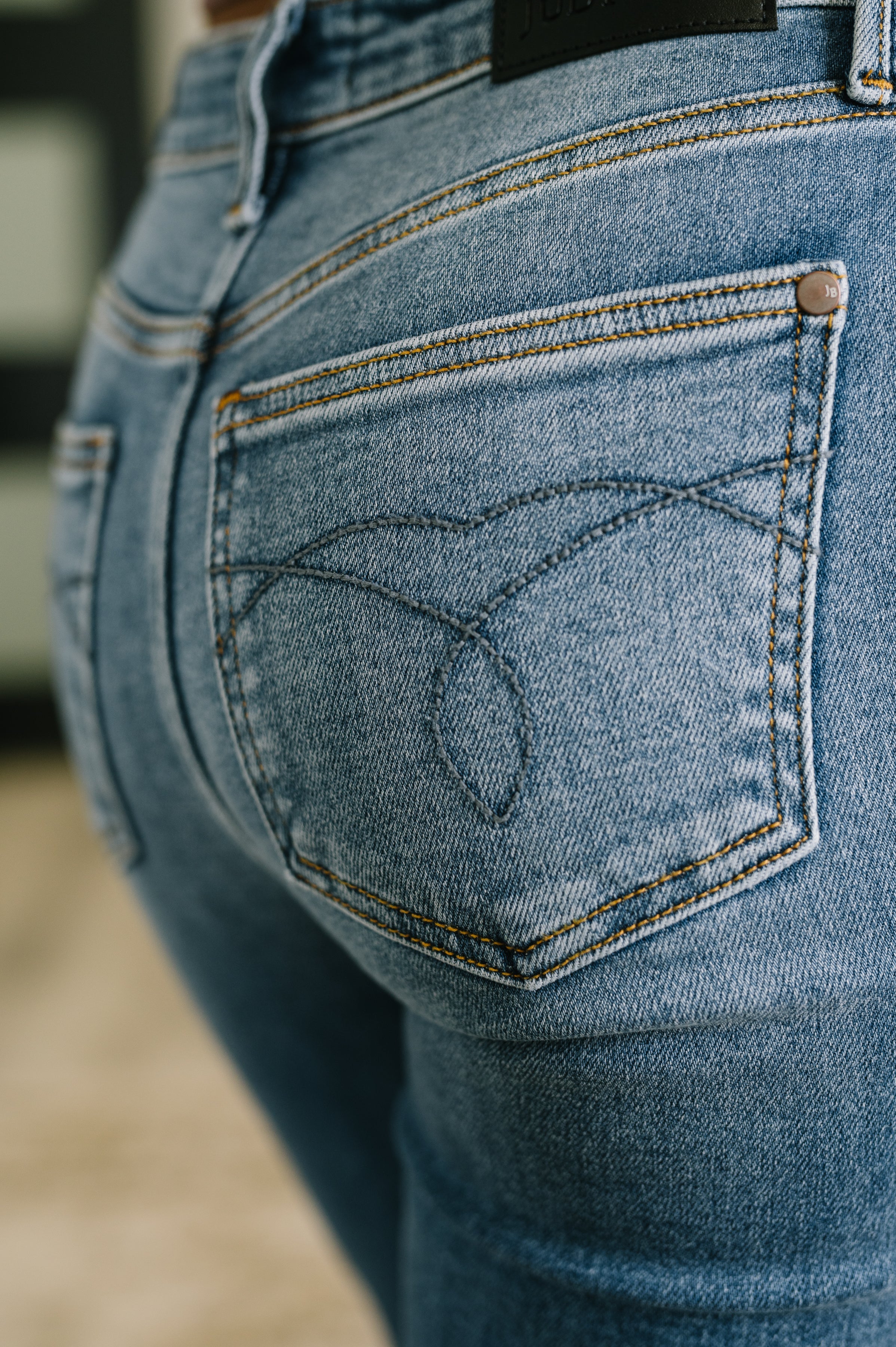 Woman wearing blue jeans standing in an indoor setting.