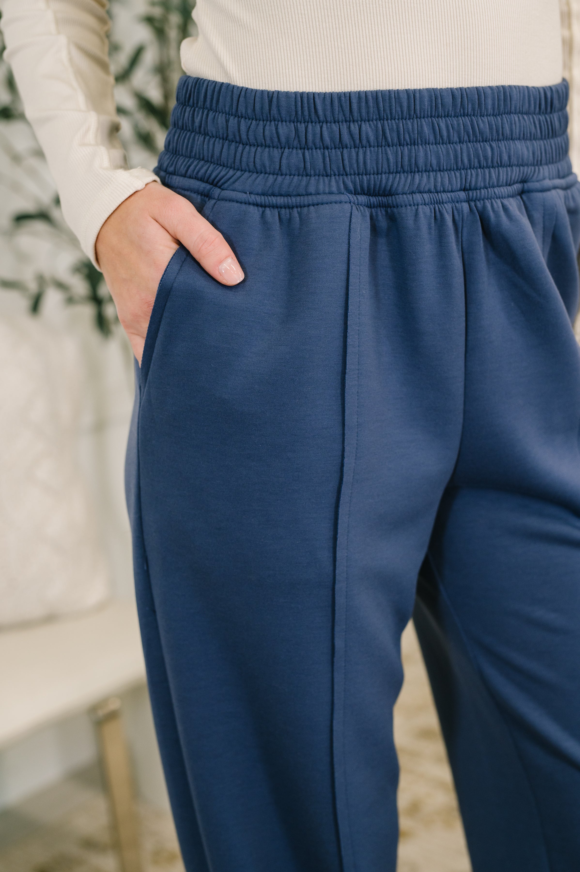 Blue jogger pants close up worn by a woman with a blurred background