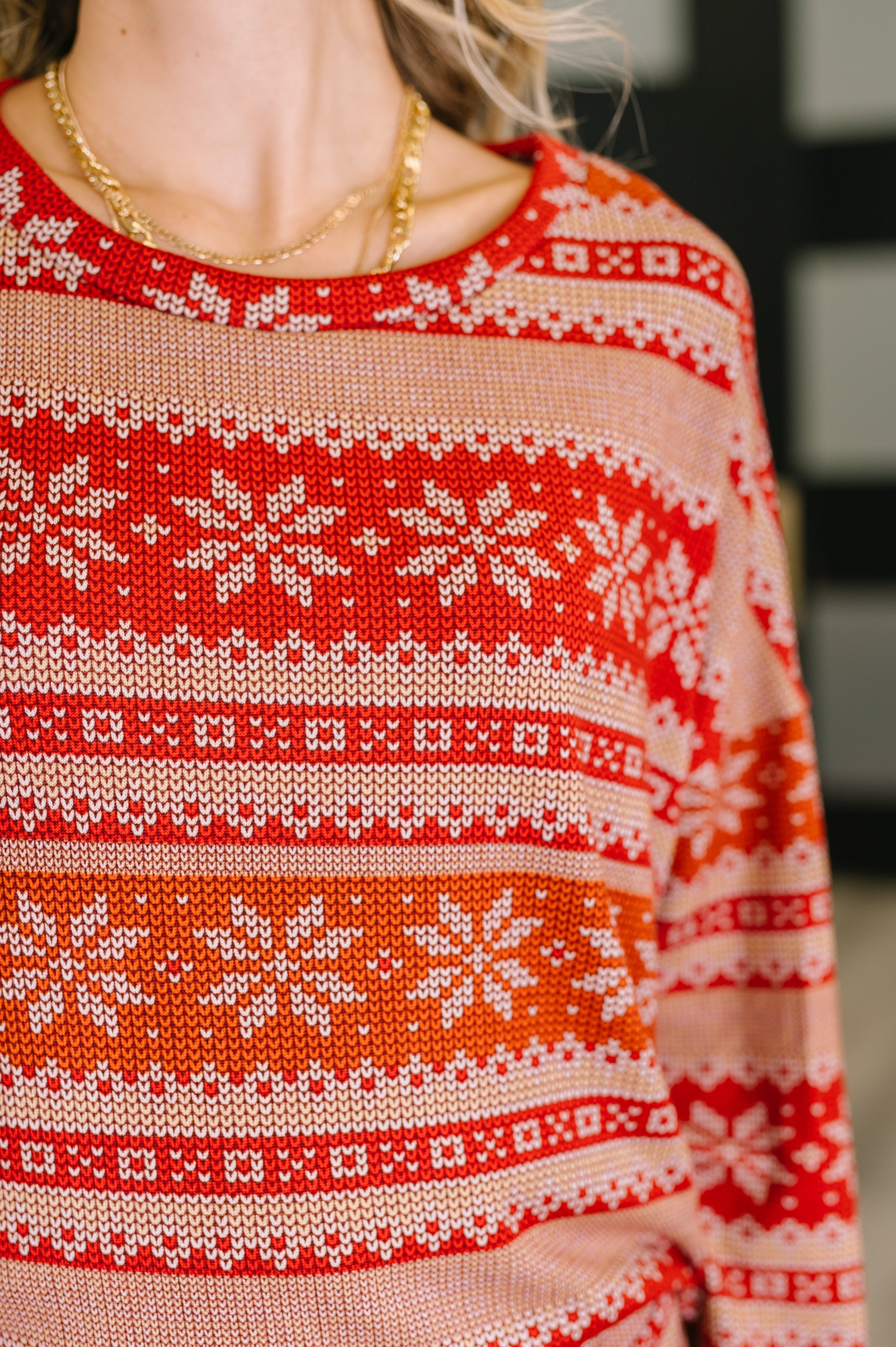 Close-up of a red and beige patterned pajama top with snowflake design.