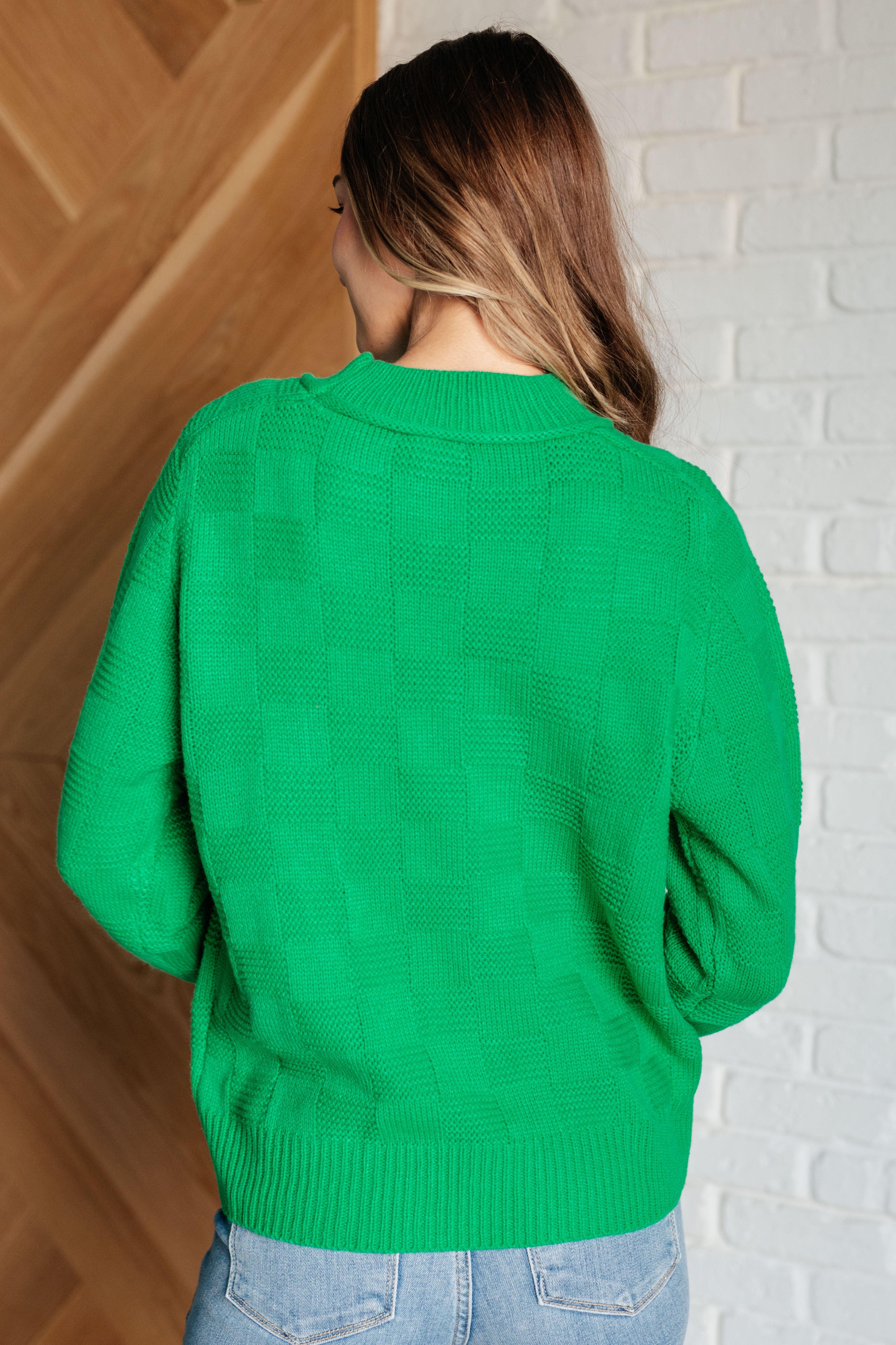 Woman with long brown hair wearing bright green textured knit pullover sweater, shown from back indoors ASongtoSingSweaterKnitPullover9.jpg