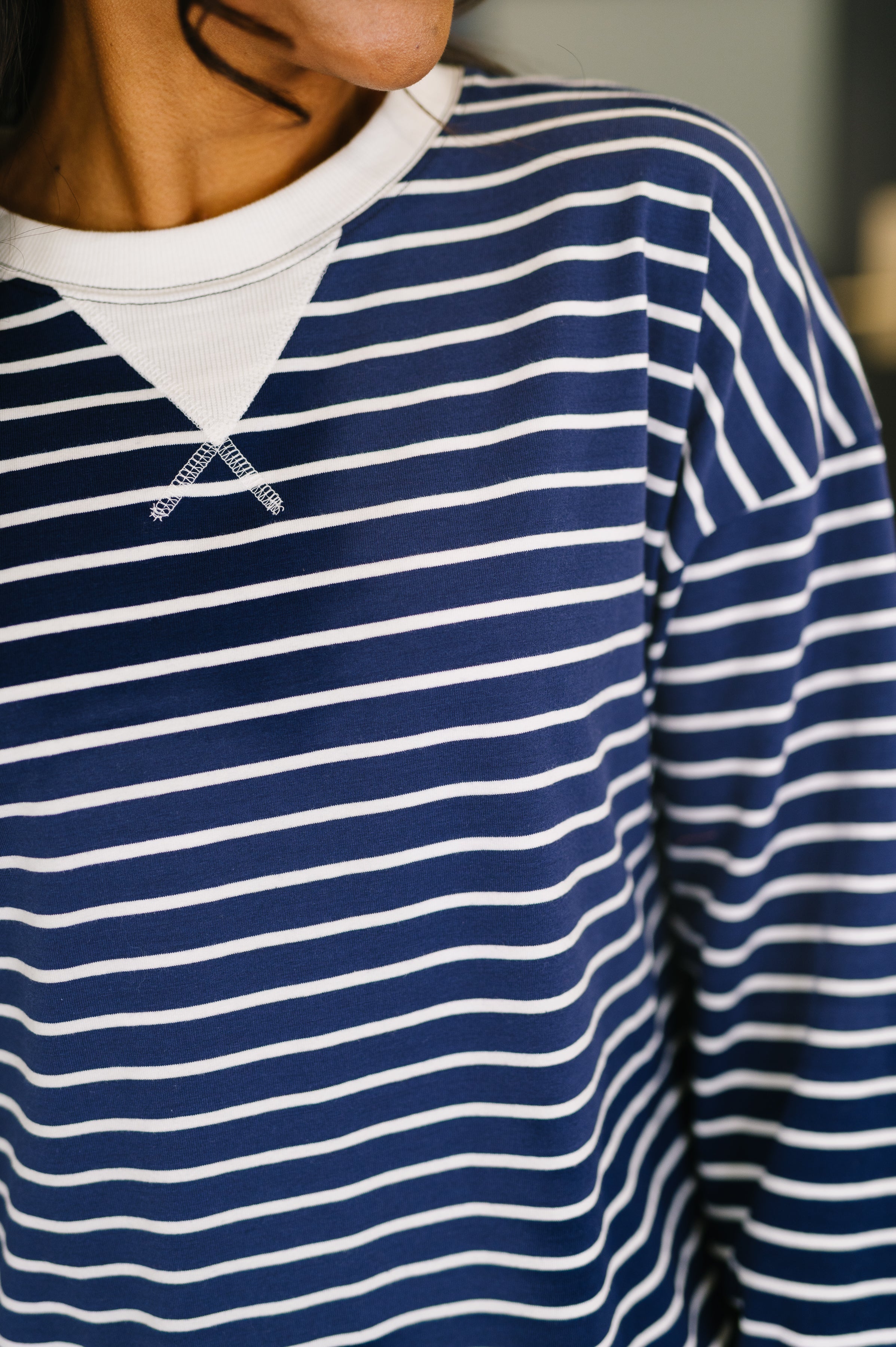 Close-up of navy Almost Therapeutic Drop Shoulder Pullover featuring white horizontal stripes and contrasting white collar detail