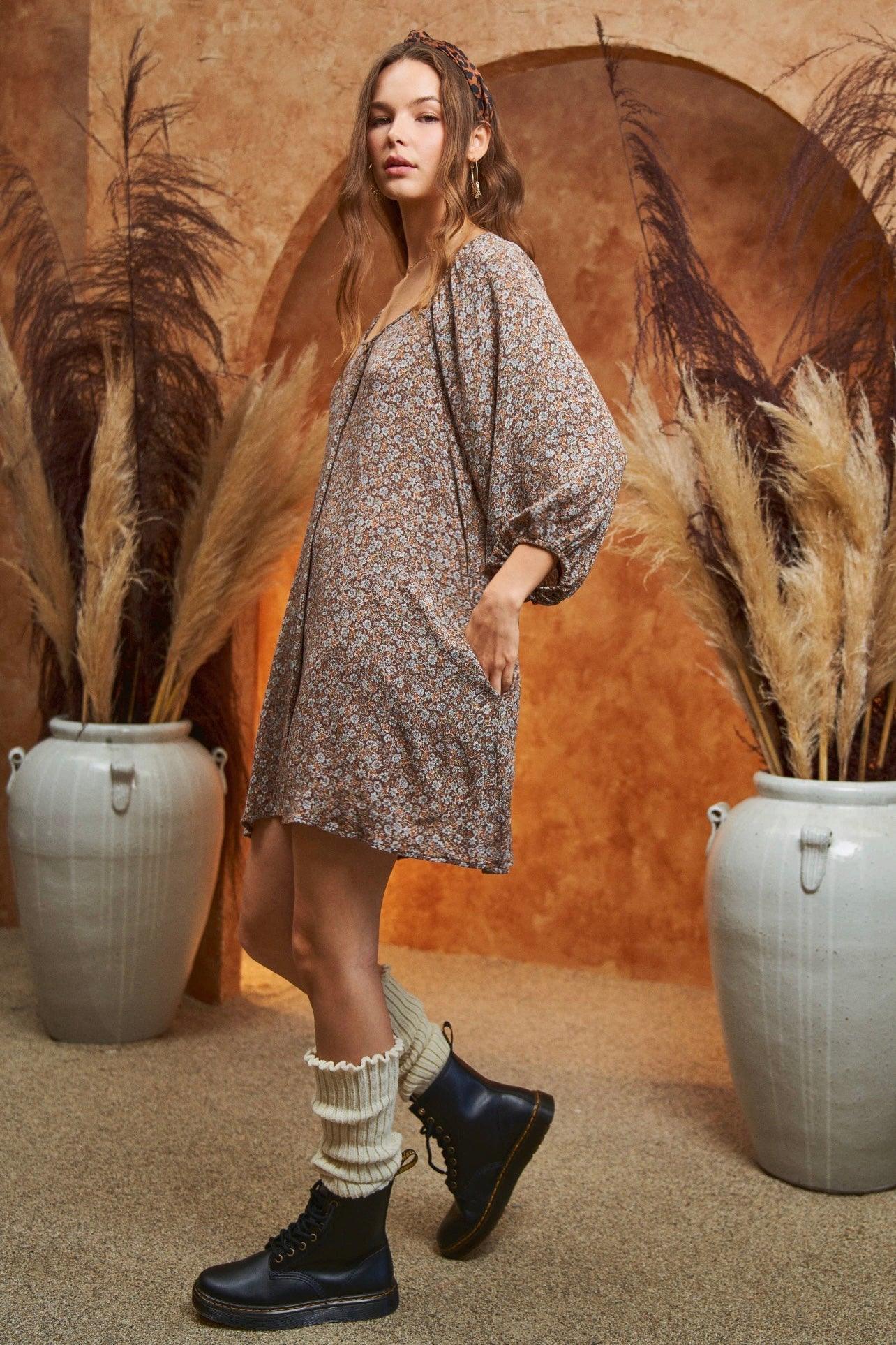 Model wearing loose Autumn Feels Floral Dress with balloon sleeves paired with socks and lace-up black boots in warm setting