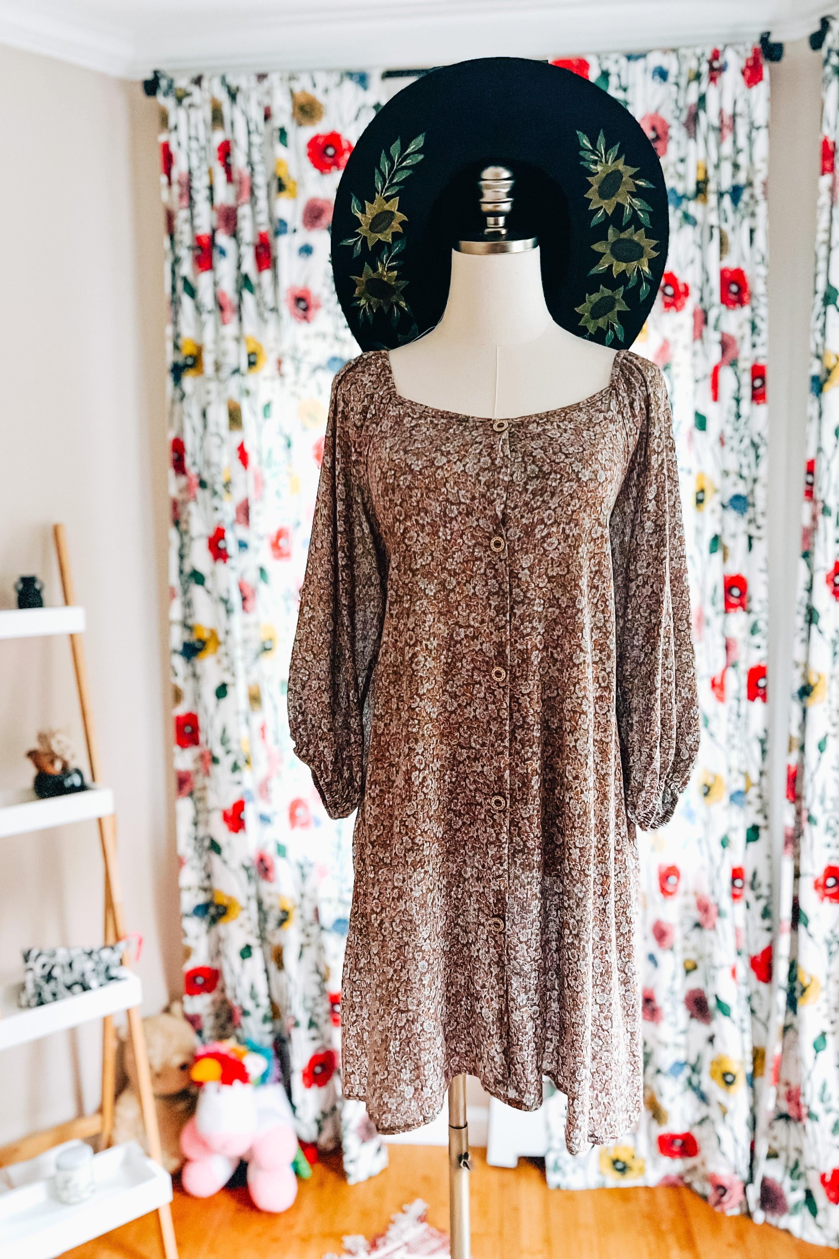 Button-front Autumn Feels Floral Dress with long sleeves displayed on mannequin in cozy room with floral curtains