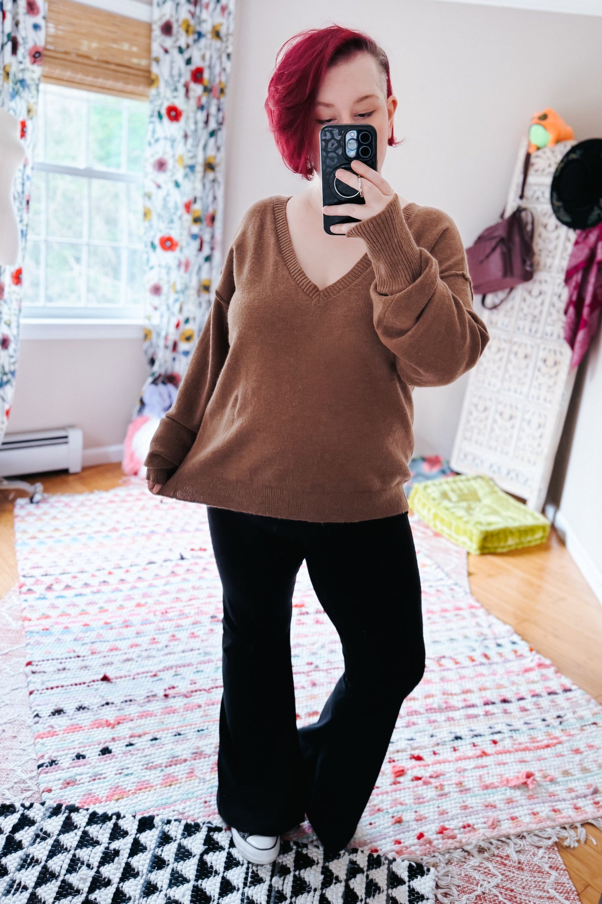 Mocha V-neck sweater with dropped shoulders and relaxed sleeves styled with black pants in a cozy bedroom mirror selfie