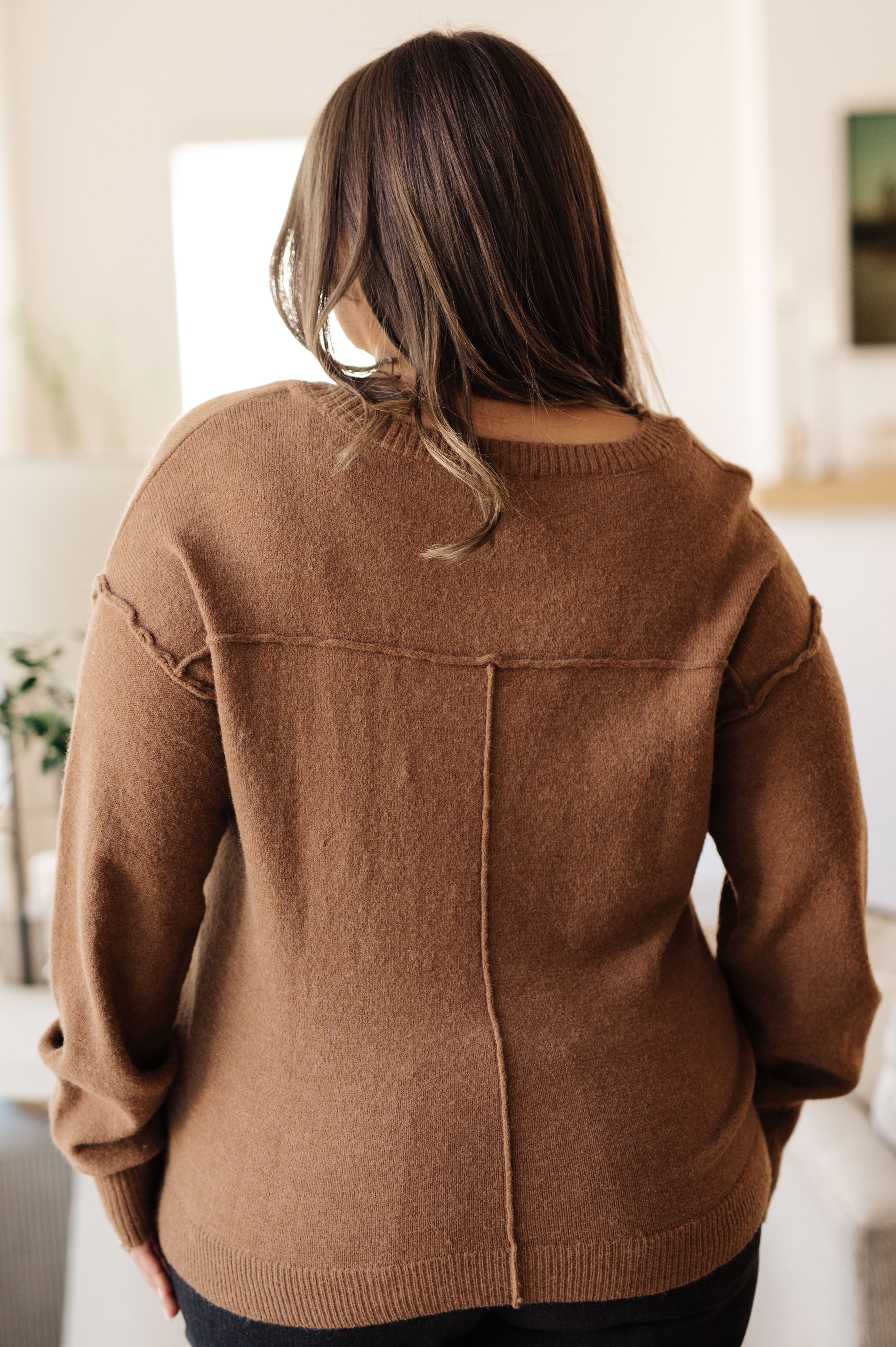 Woman shown from behind wearing mocha Back to Life V-Neck Sweater with visible vertical and horizontal seam details
