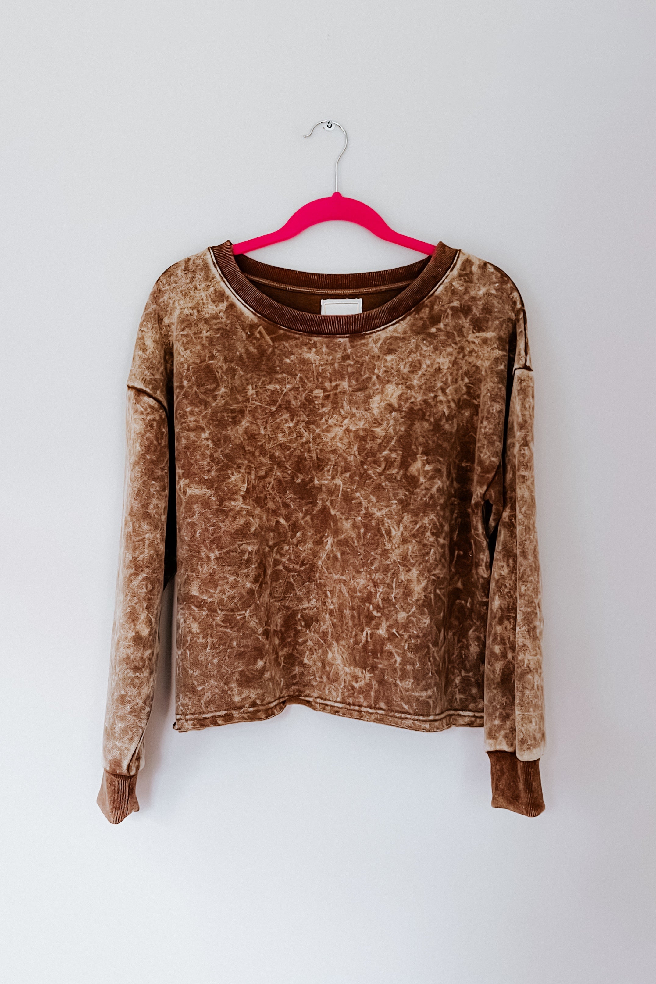 Mocha acid wash cropped pullover hanging on bright pink hanger against plain white background, gallery 0, D27F6424.jpg