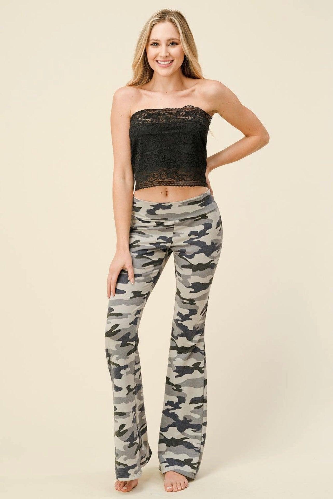 Front view of high-waisted flare pants with grey and navy blue camouflage print worn barefoot by smiling model