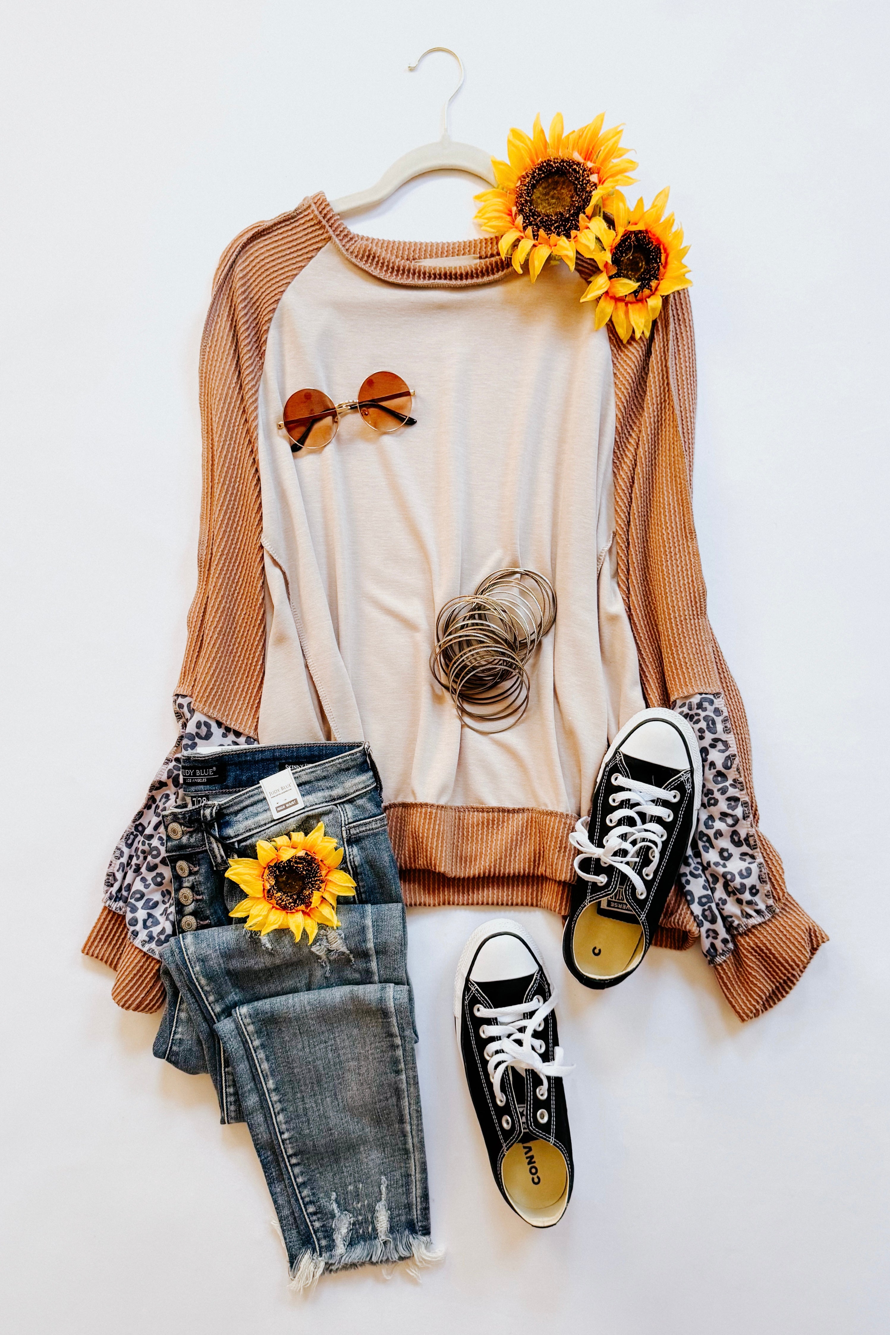 Beige dolman colorblock terry top with rust ribbed sleeves and leopard print detail styled with sunglasses, bracelets, jeans, and black sneakers
