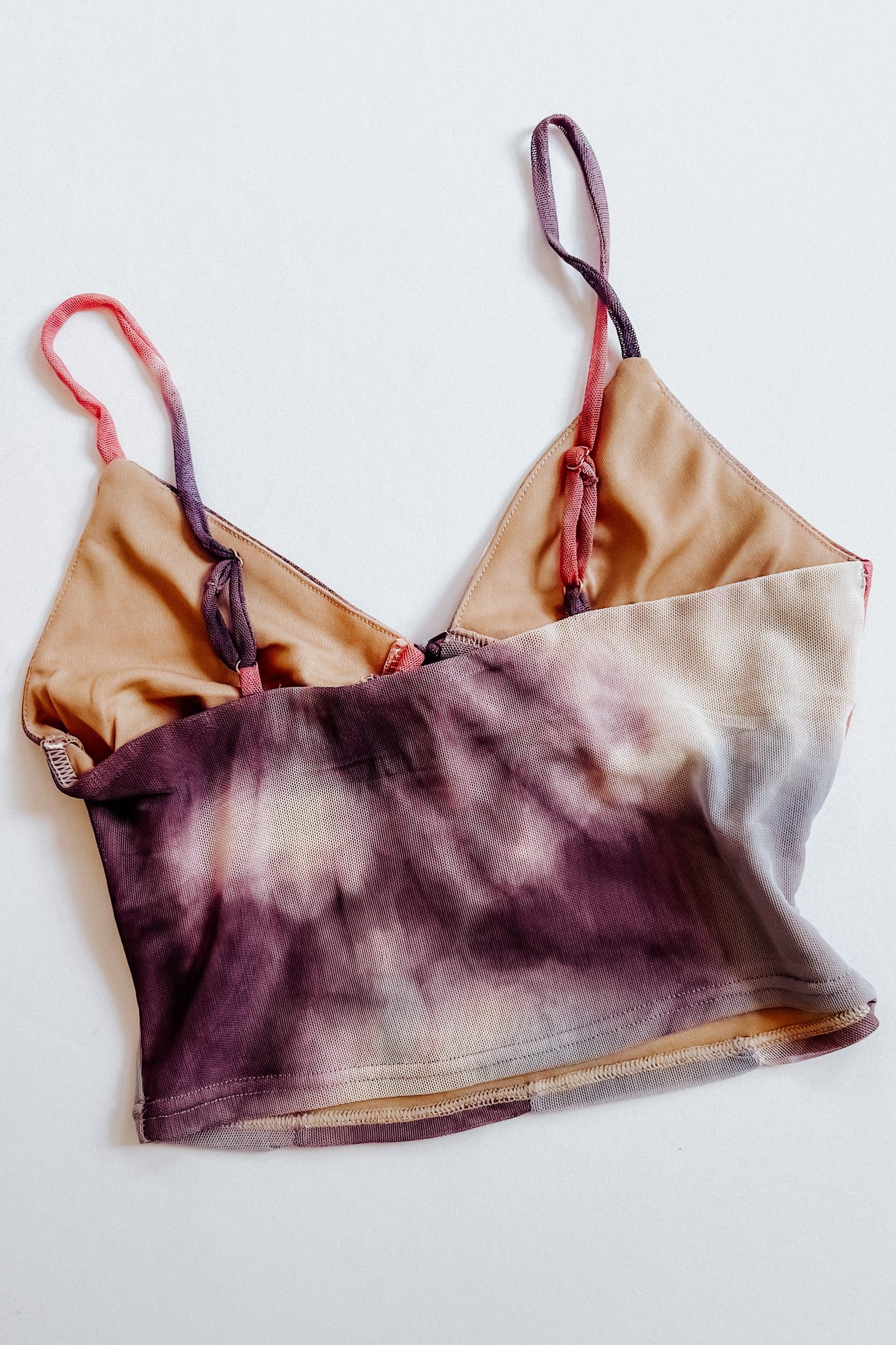 Purple and beige tie dye mesh brami top with thin adjustable straps laid flat on white background