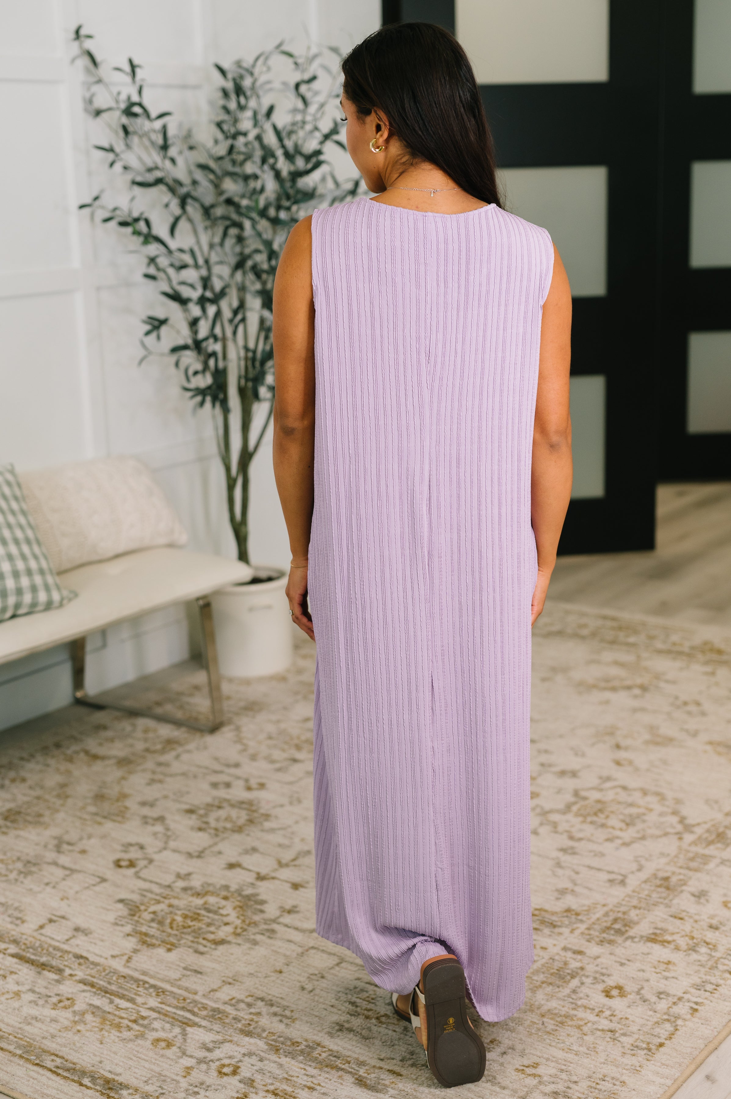 Woman wearing a lavender sleeveless maxi dress with ribbed texture standing indoors on patterned rug