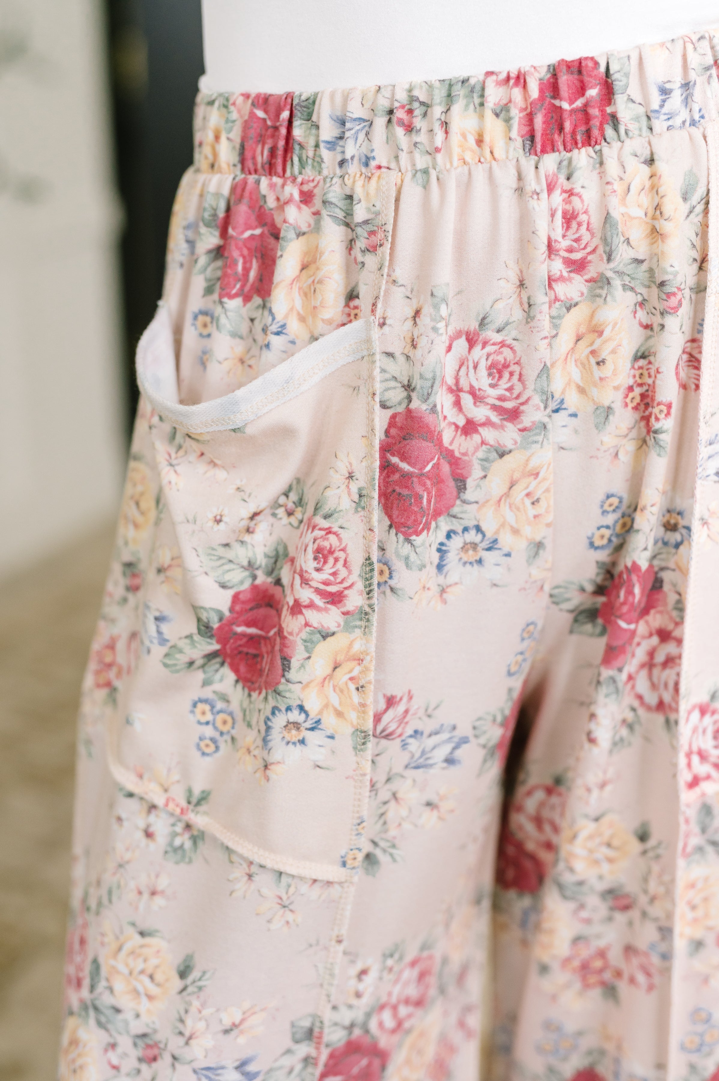 Close up of pink floral wide leg bottoms with an elastic waistband and side pockets