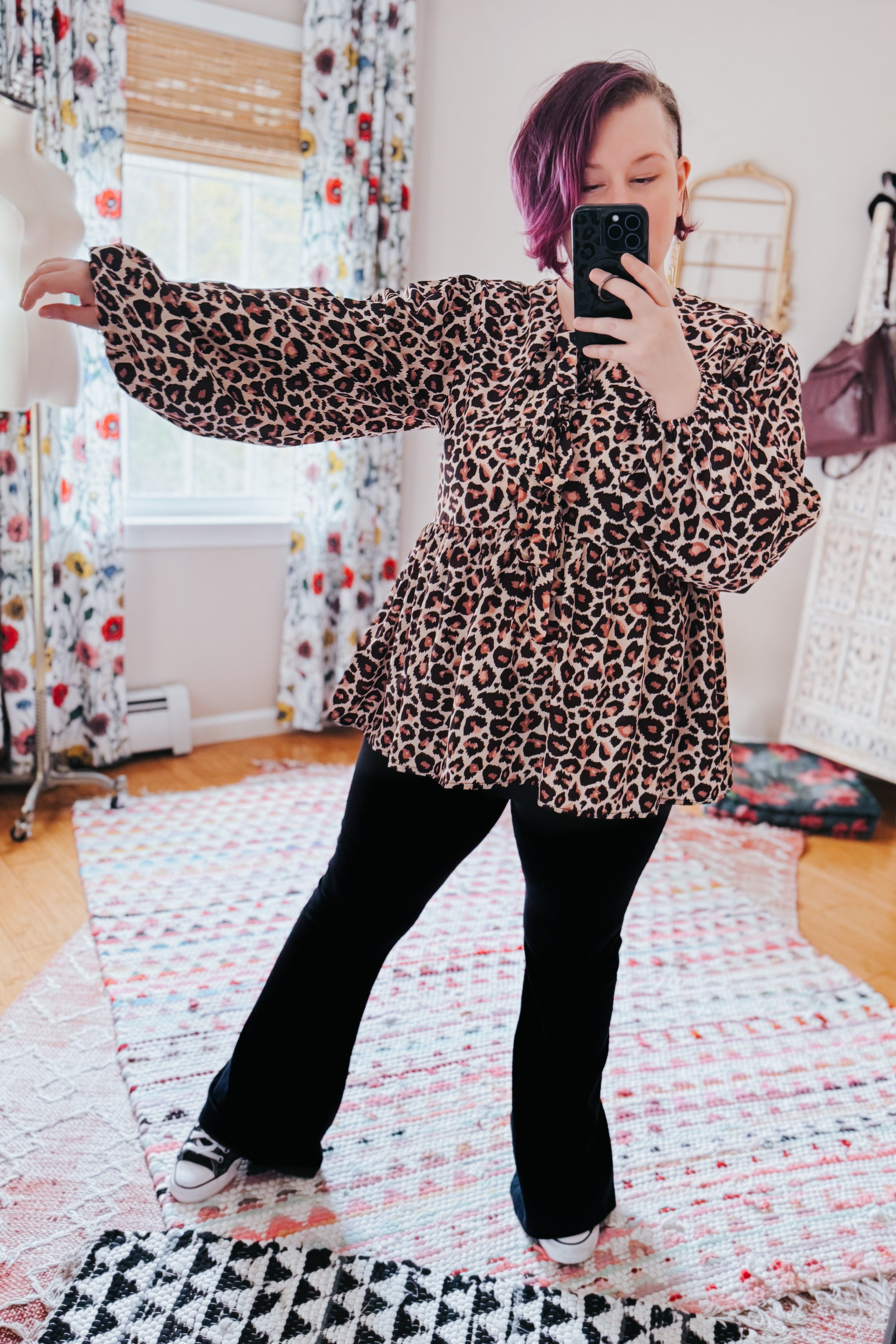 Brown leopard pattern babydoll blouse with long puff sleeves worn with black pants and sneakers in cozy bright room selfie