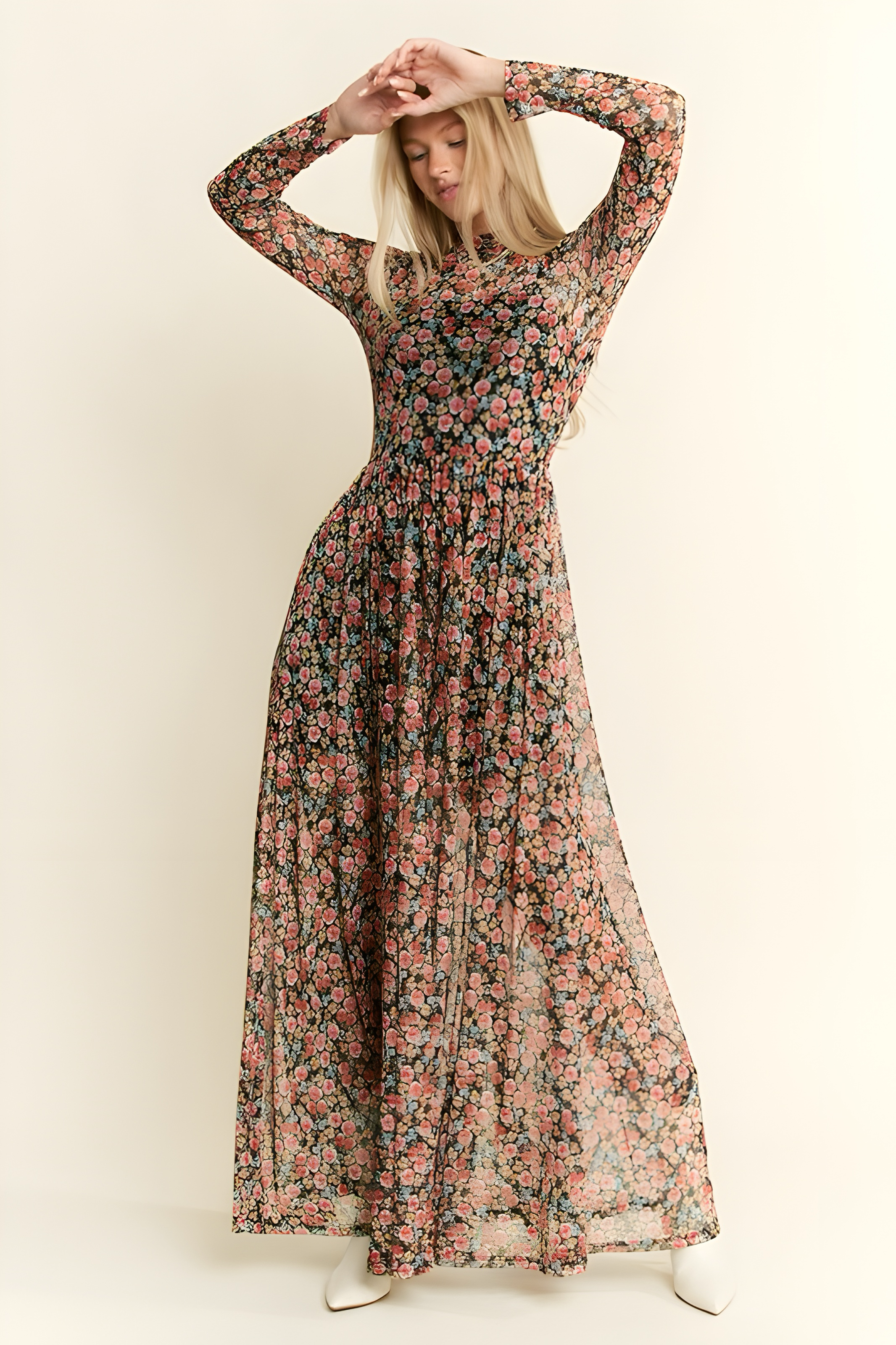 Blonde woman wearing sheer long sleeve floral mesh maxi dress with red and pink small flowers on dark background