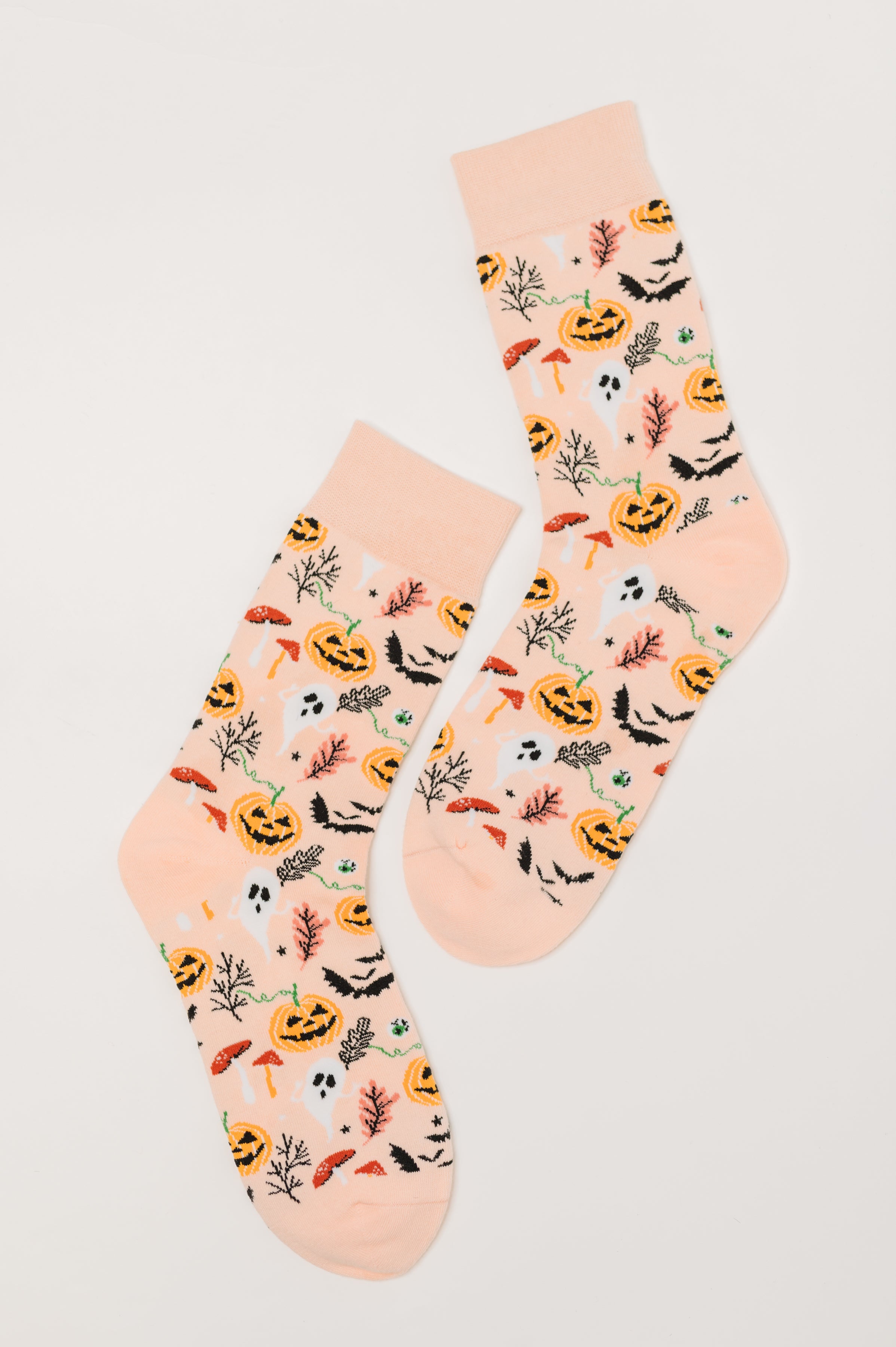 Pair of orange quarter socks decorated with Jack-o'-lanterns, ghosts, bats, mushrooms, and autumn leaves on light background