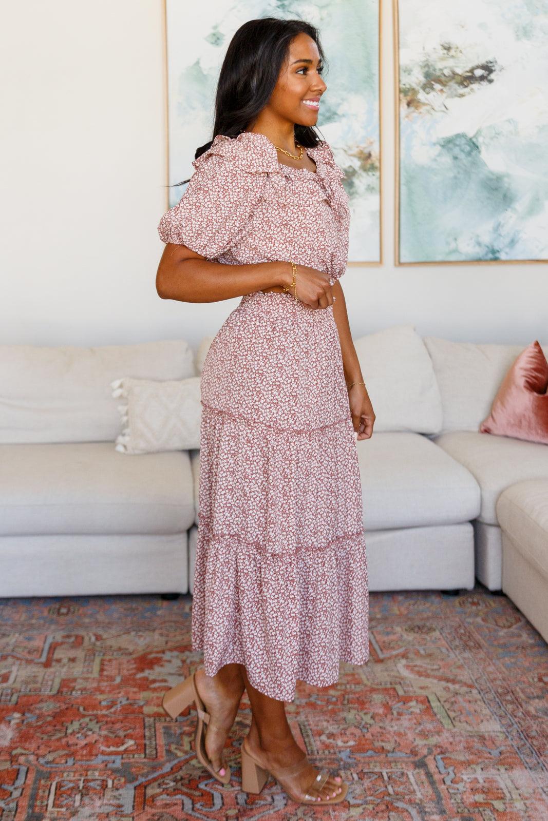 Woman standing indoors wearing a rose floral puff sleeve crop top paired with a tiered matching midi skirt and heels