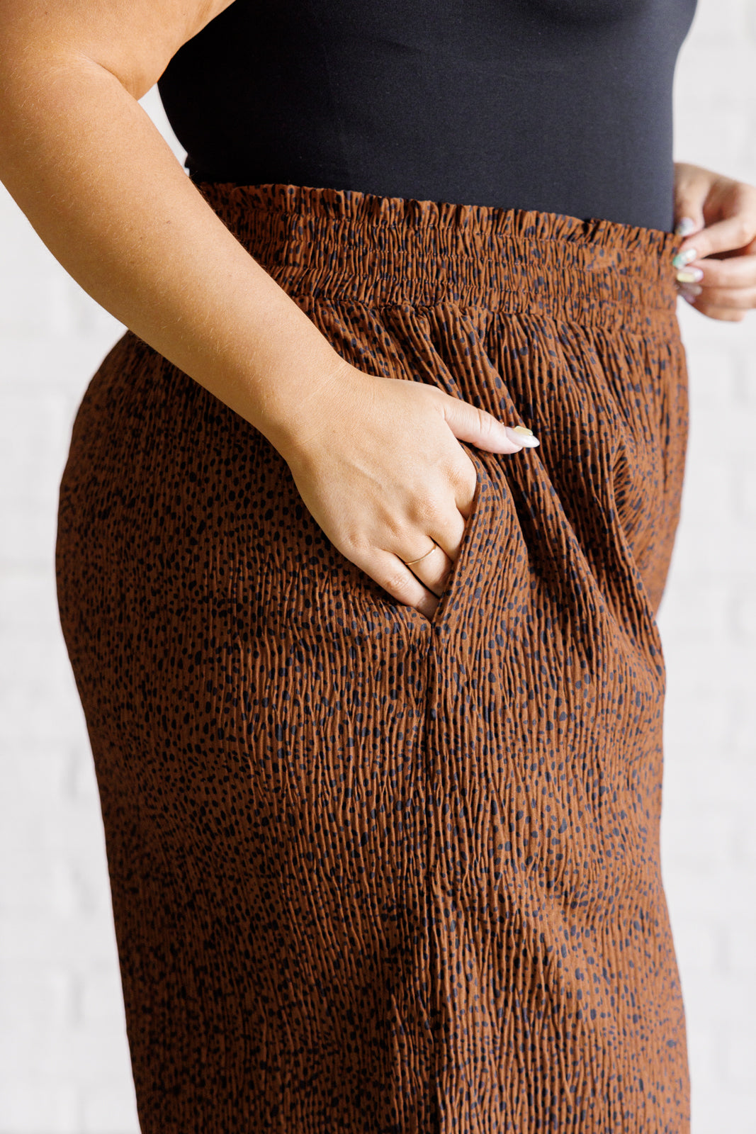 Close-up of brown Harmony high rise wide leg pants with textured fabric showing side pocket and elastic waistband