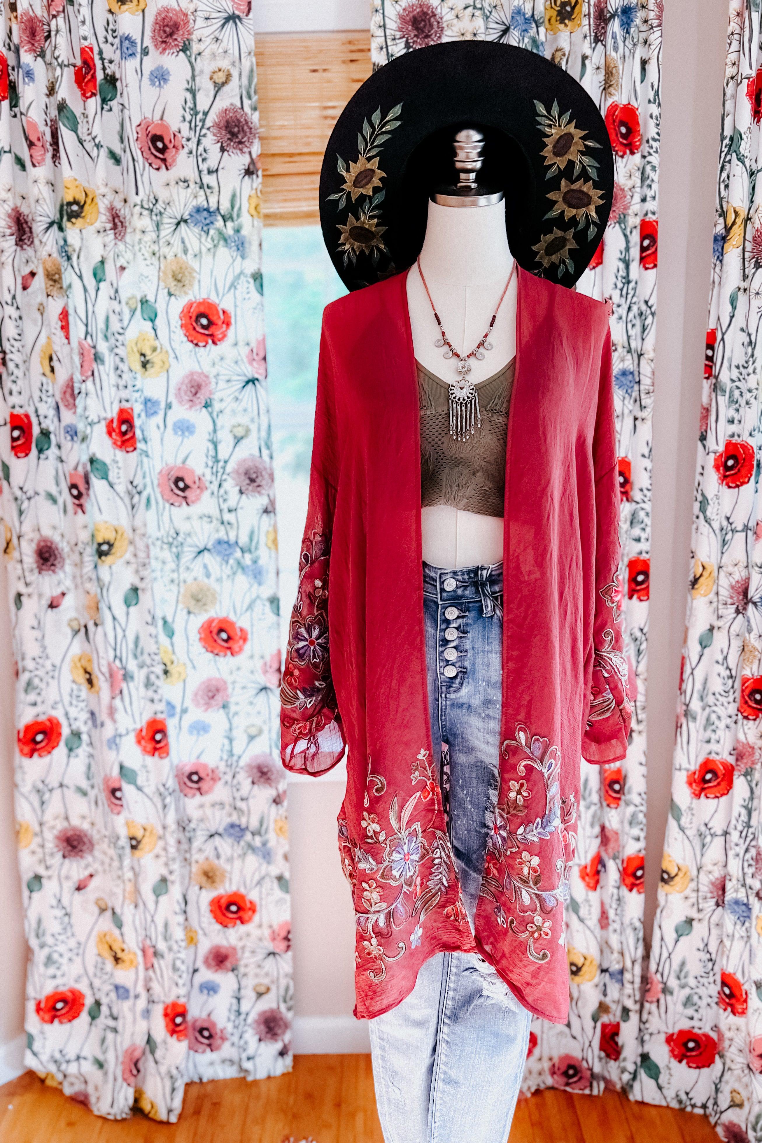 Crimson In The Meadow embroidered duster styled over olive crop top and high-rise button fly jeans on mannequin with floral hat
