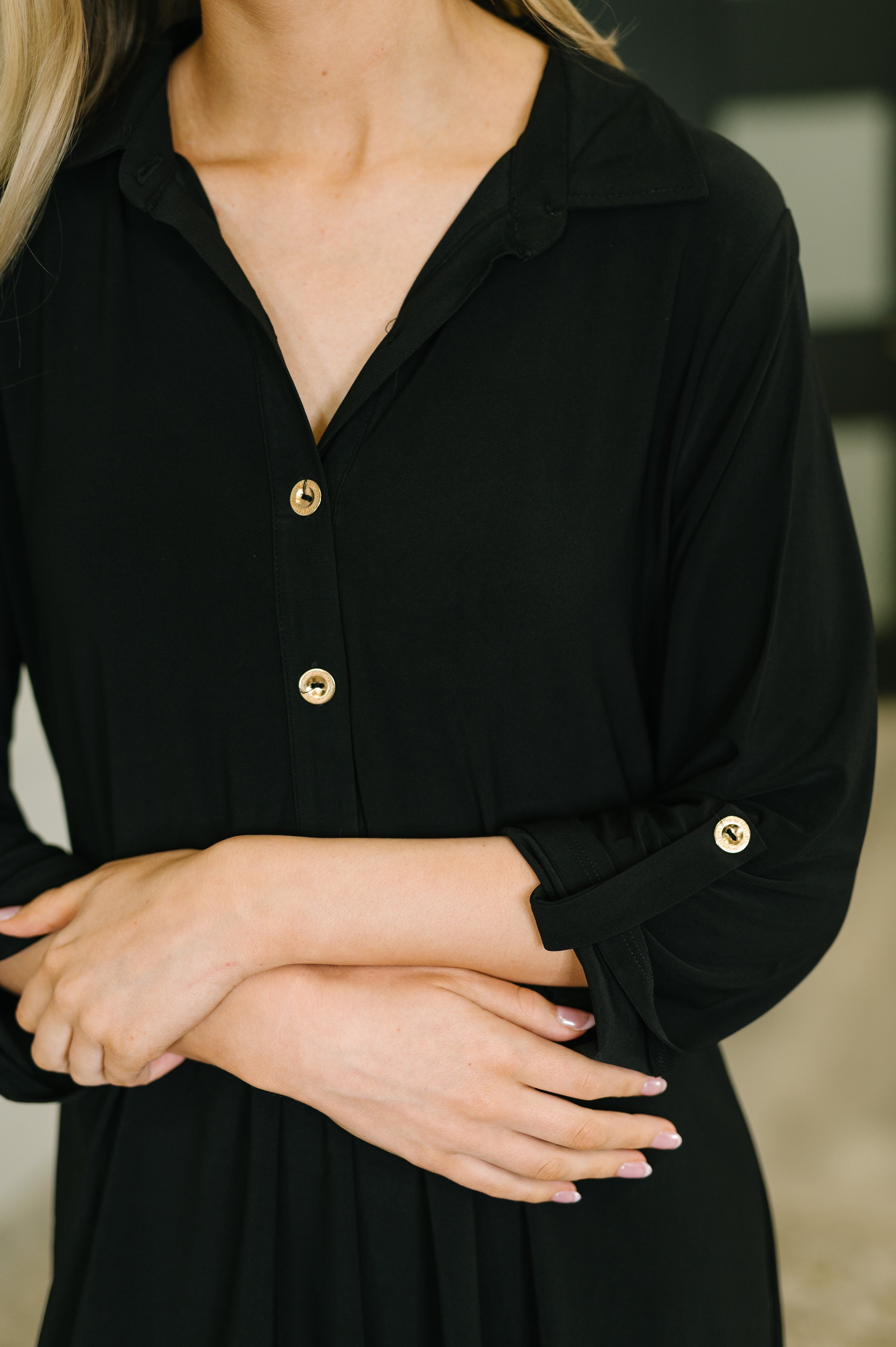Close-up of black Inspire Collared Neck Dress featuring button details on front placket and rolled-up sleeves