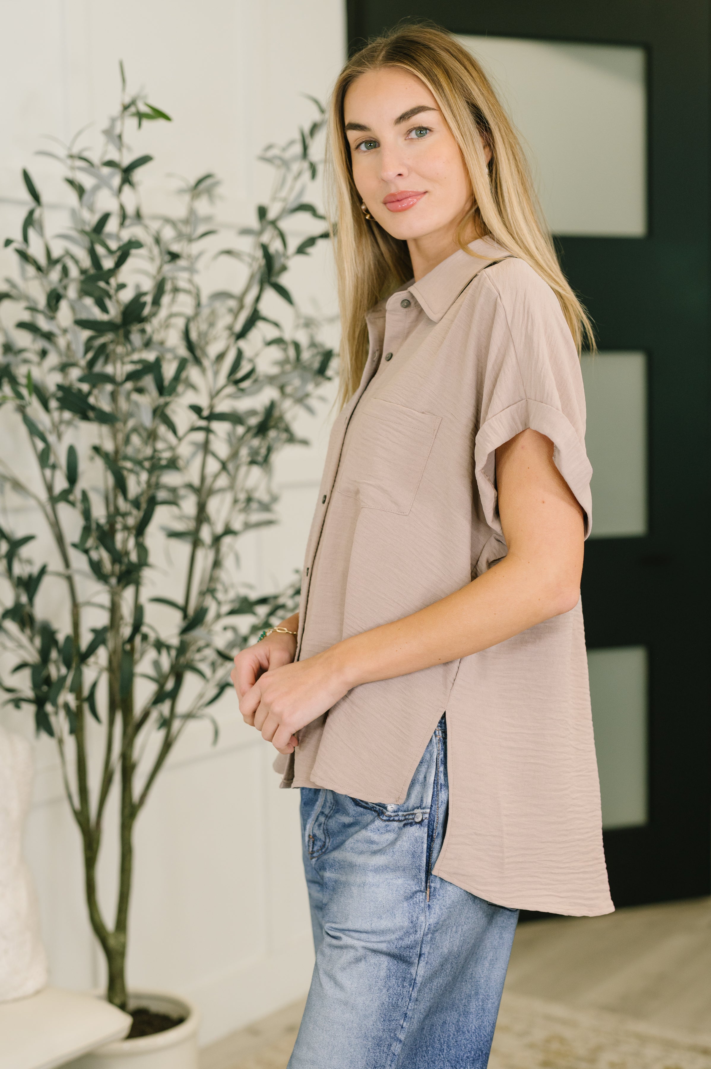 Side view of ash mocha crinkle woven button-down top with short sleeves styled with relaxed denim in a free-spirited vibe