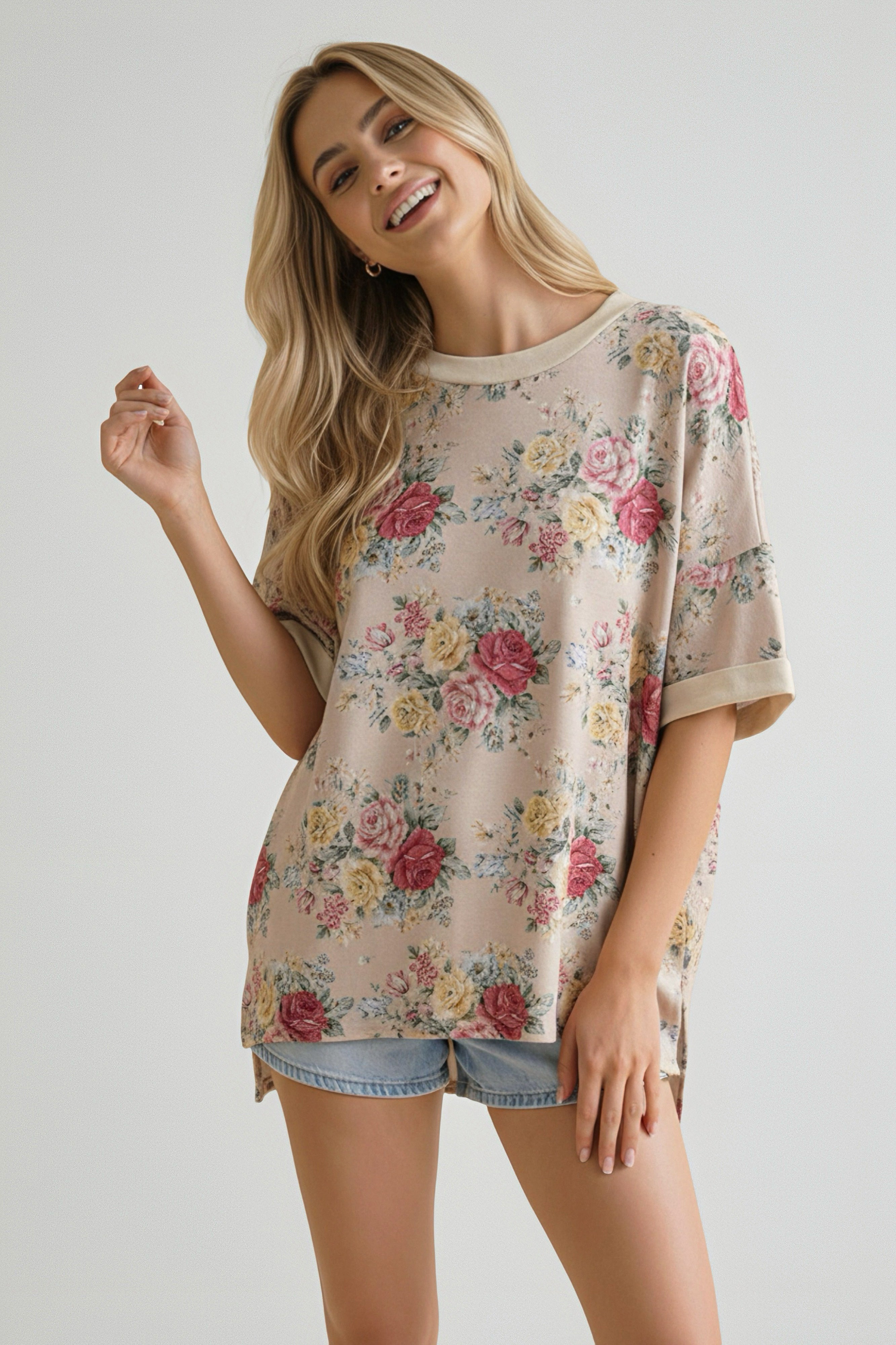 Smiling woman with long blonde hair wearing an oatmeal floral print relaxed short sleeve top with rolled cuffs