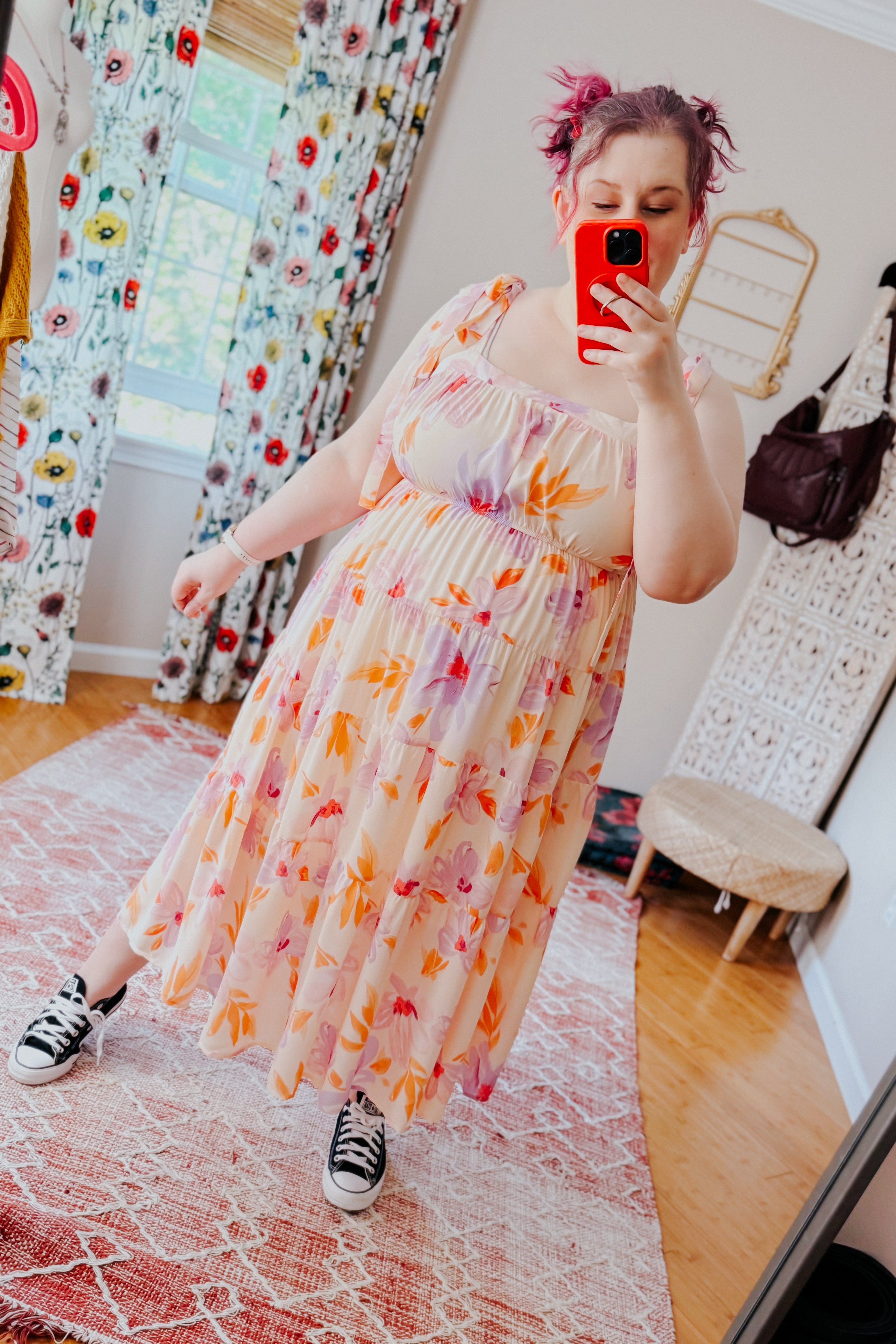 Plus-size woman in peach and lavender floral midi dress with puffed sleeves and tiered skirt taking mirror selfie indoors