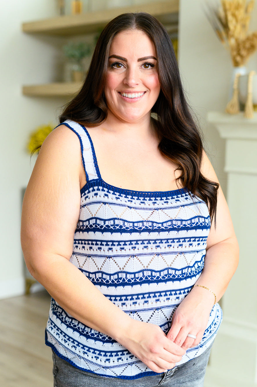 Smiling woman wearing a blue patterned knitted sweater tank with wide straps and a relaxed fit indoors