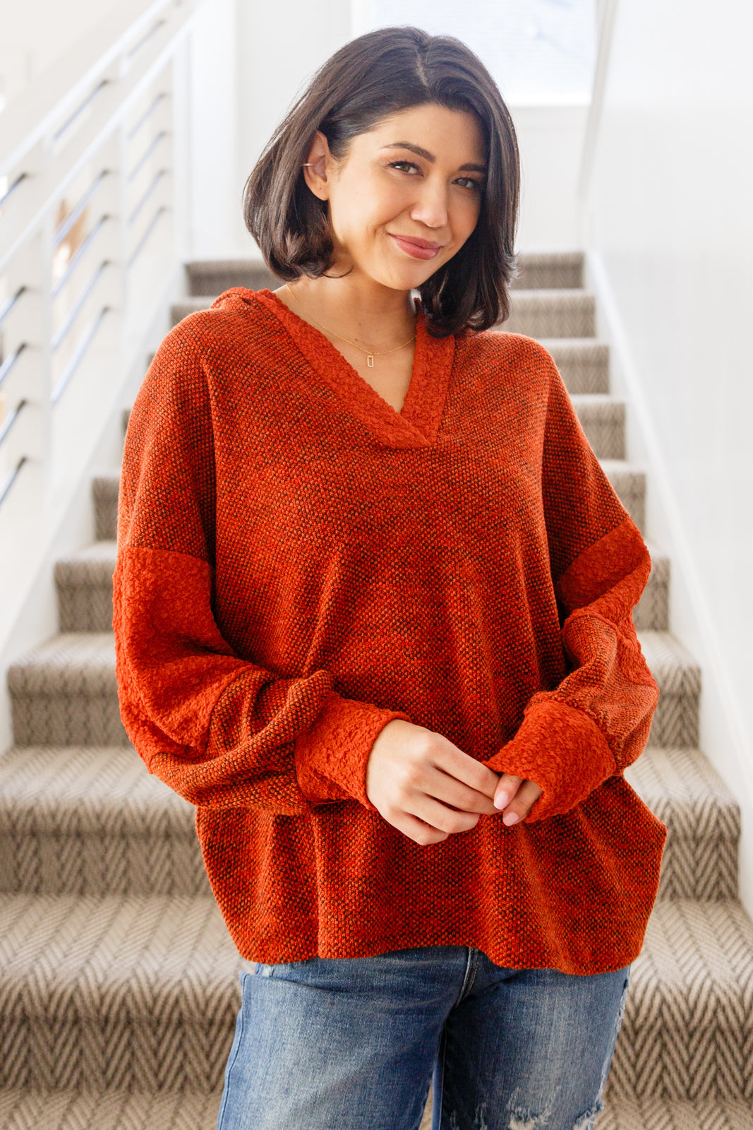 Woman wearing rust color block hoodie with textured knit and relaxed fit in eclectic, size-inclusive style