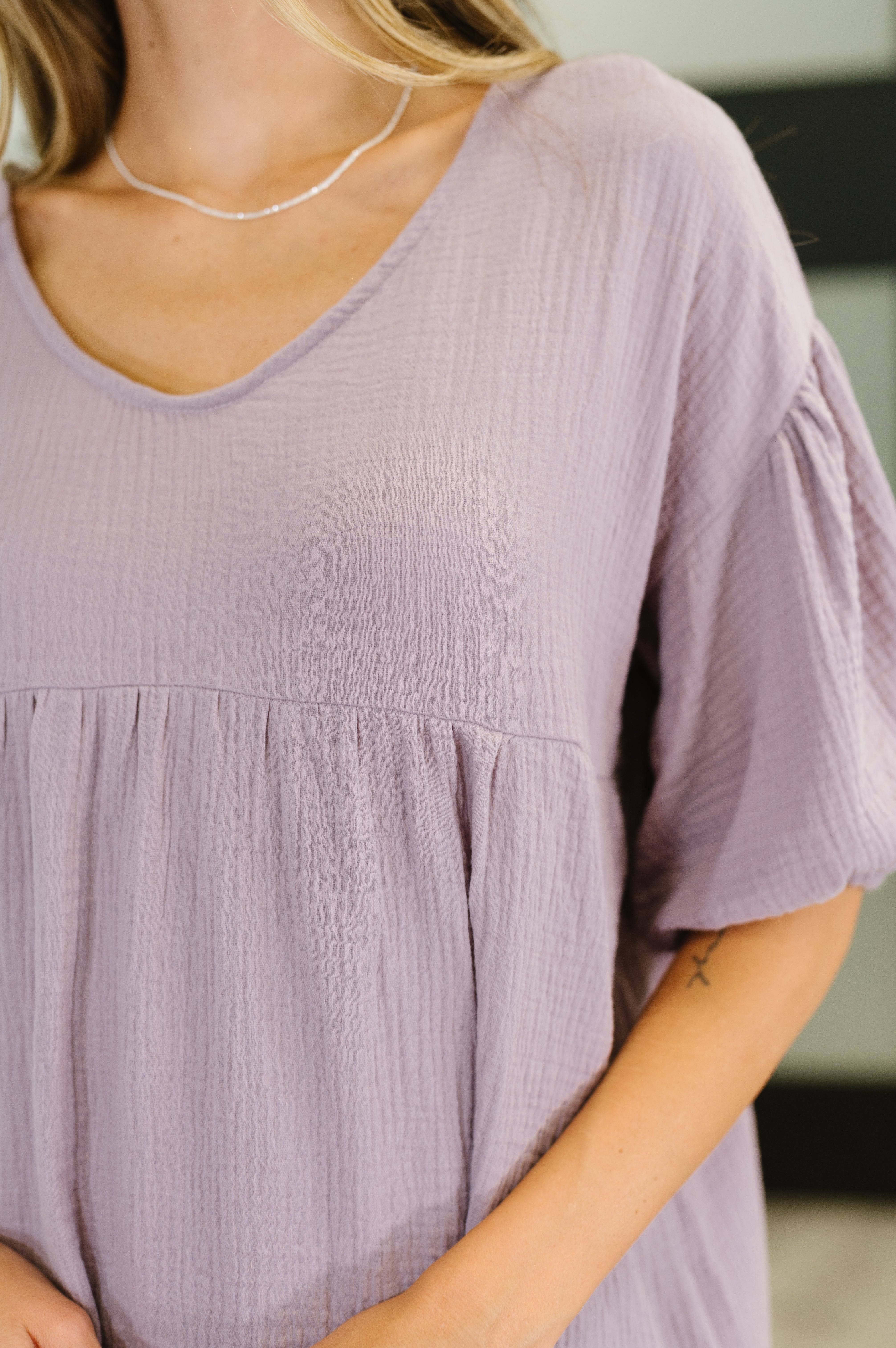 Close-up of lavender peasant blouse with bubble sleeves in plush textured fabric and relaxed, free-spirited style