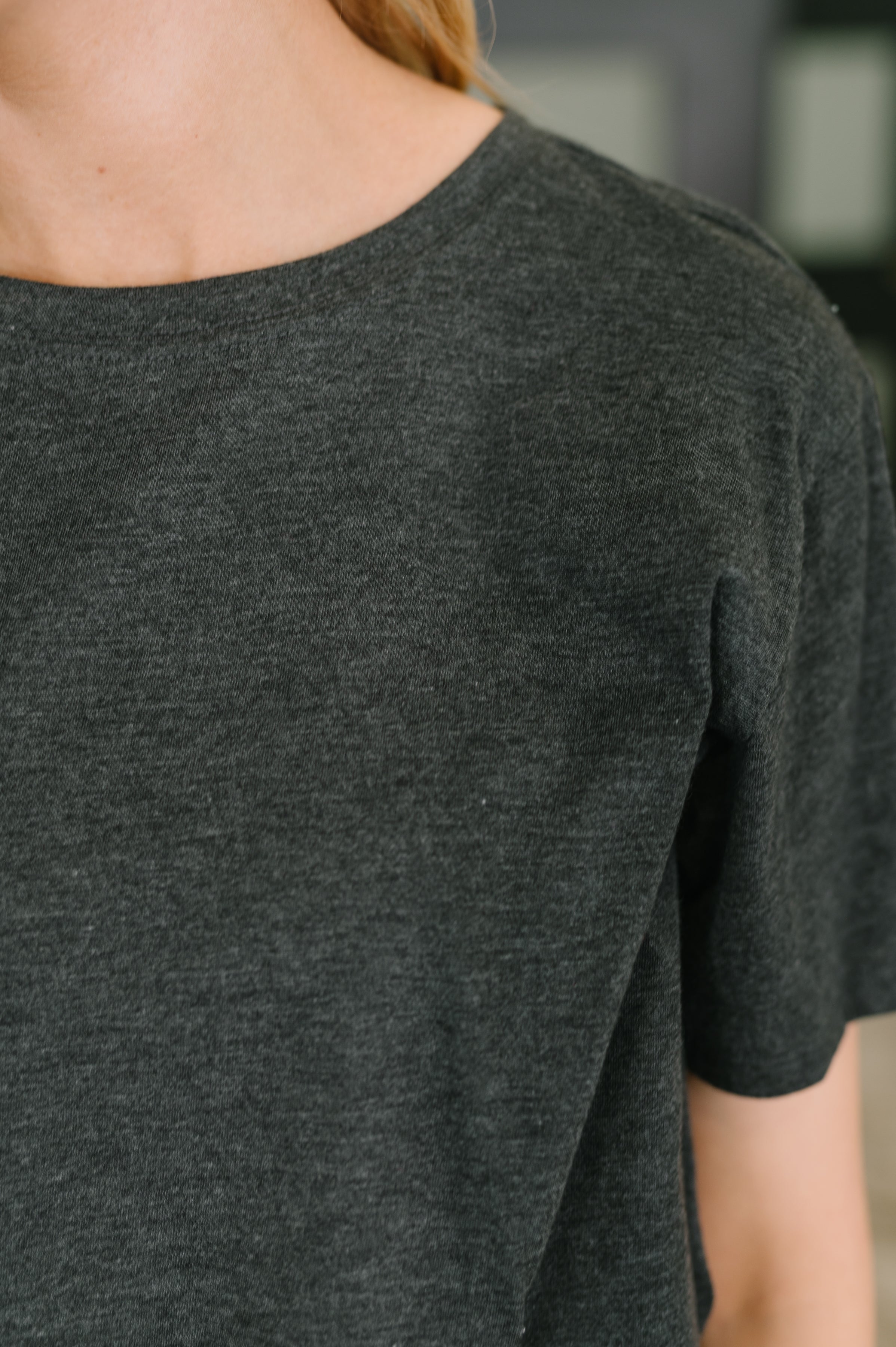 Close-up of soft charcoal jersey knit tee with relaxed fit and short sleeves on a person in casual setting