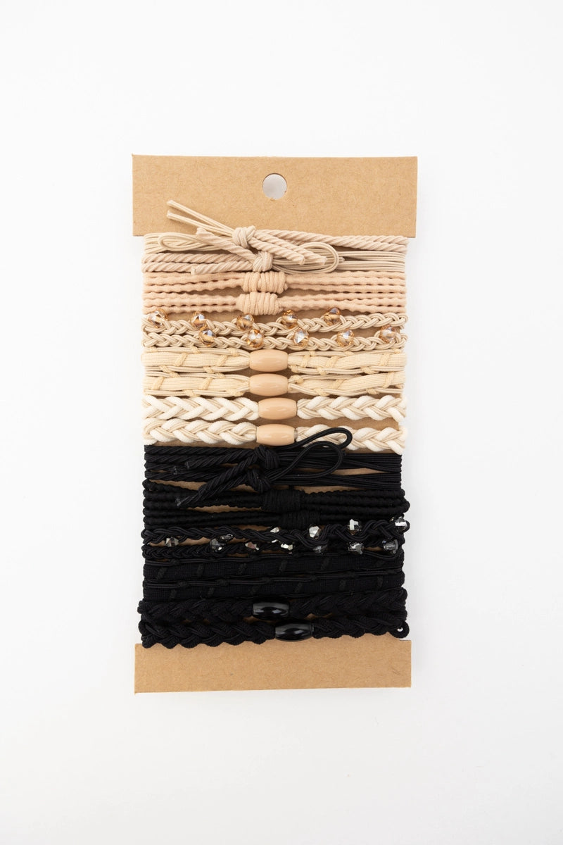 Set of cream and black textured stackable hair tie bracelets with bead and braided details on kraft card backing