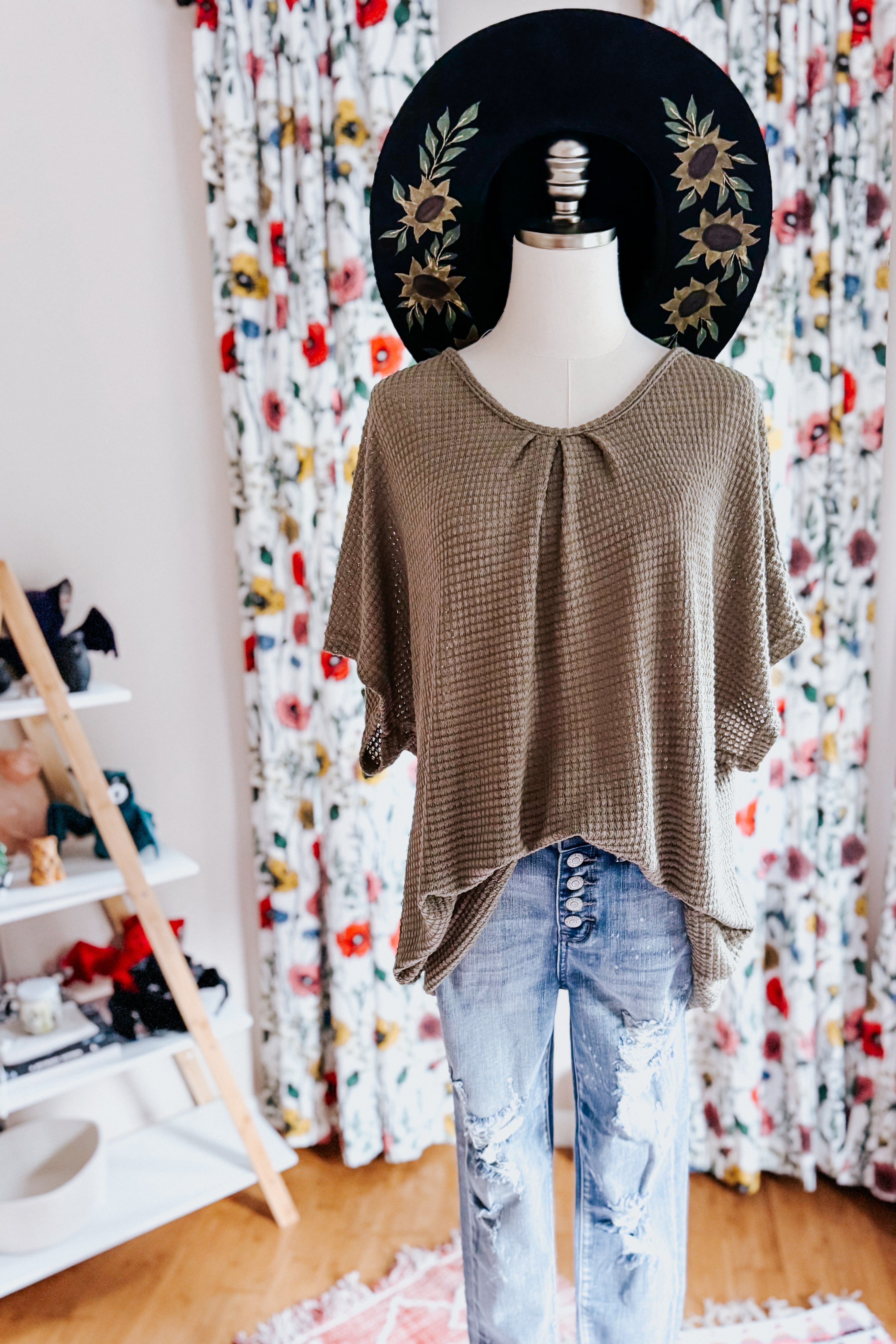Olive waffle-knit loose top with short sleeves paired with distressed light denim jeans on mannequin indoors