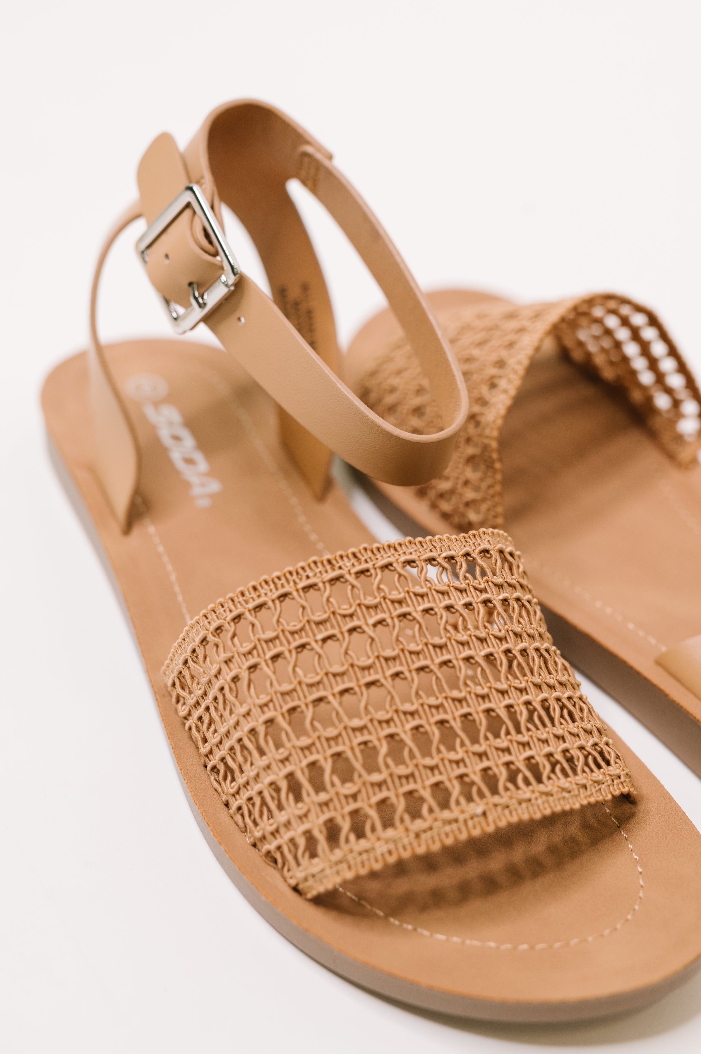 Camel sandal featuring woven front strap and adjustable ankle buckle for a free-spirited, eclectic look