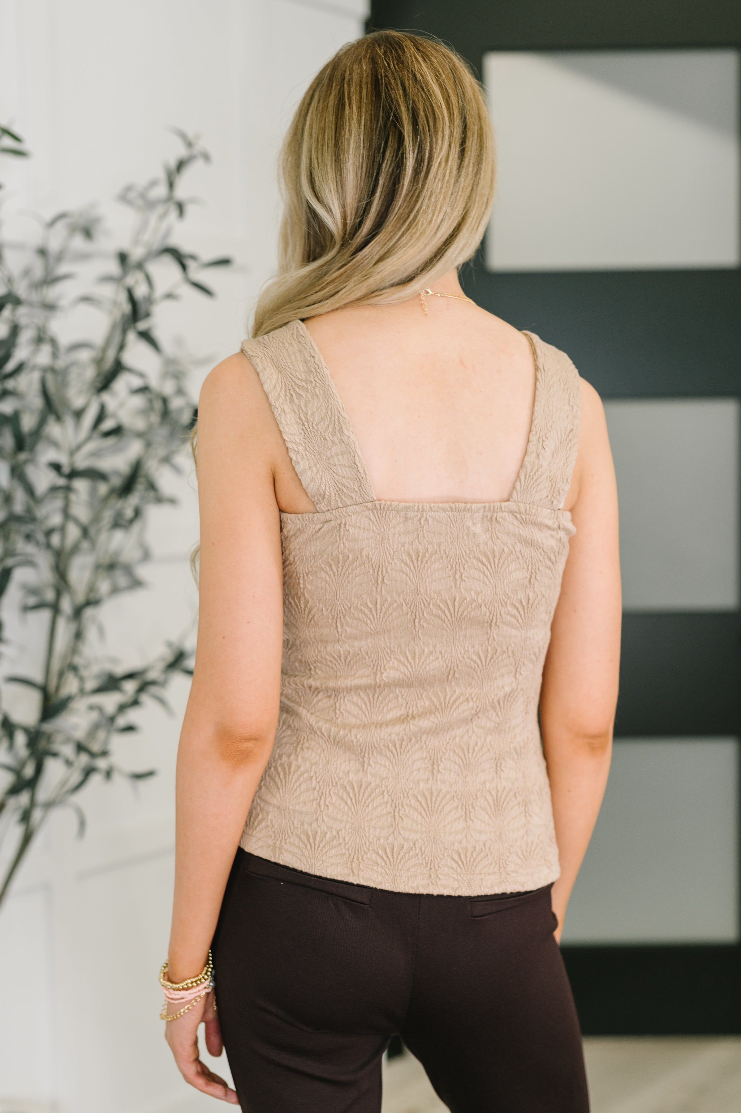 Beige floral jacquard tank with wide straps worn by model with blonde hair, paired with dark pants indoors