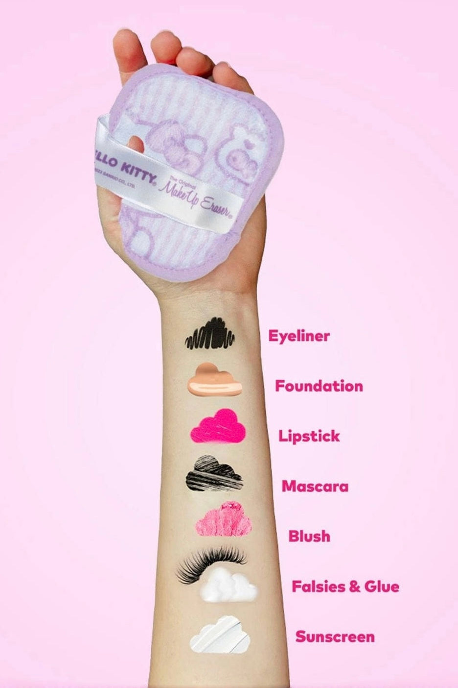 Hand holding pastel purple Hello Kitty makeup eraser with various makeup swatches on forearm against pink background