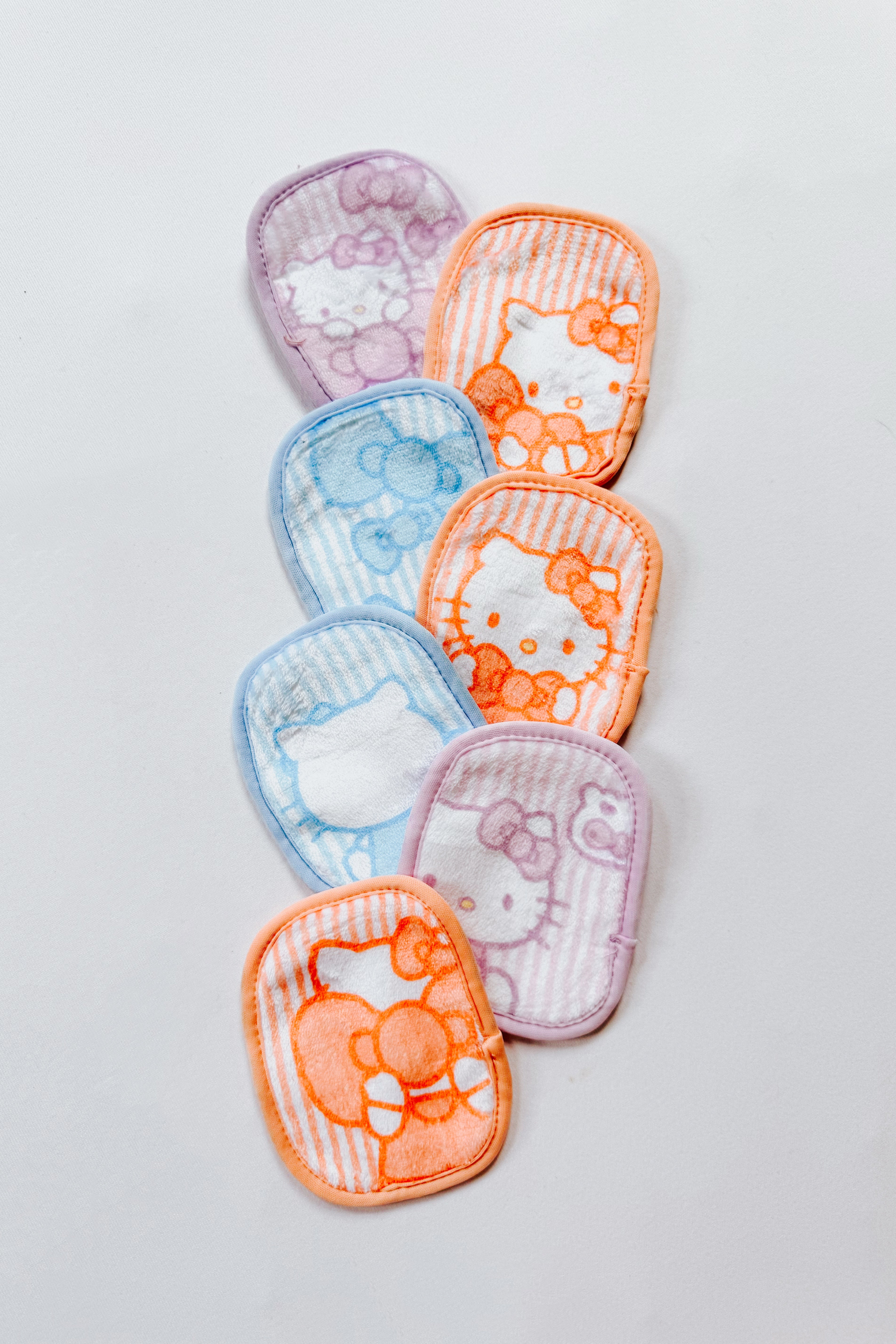 Set of soft microfiber makeup eraser pads featuring Hello Kitty designs in orange, blue, and purple tones