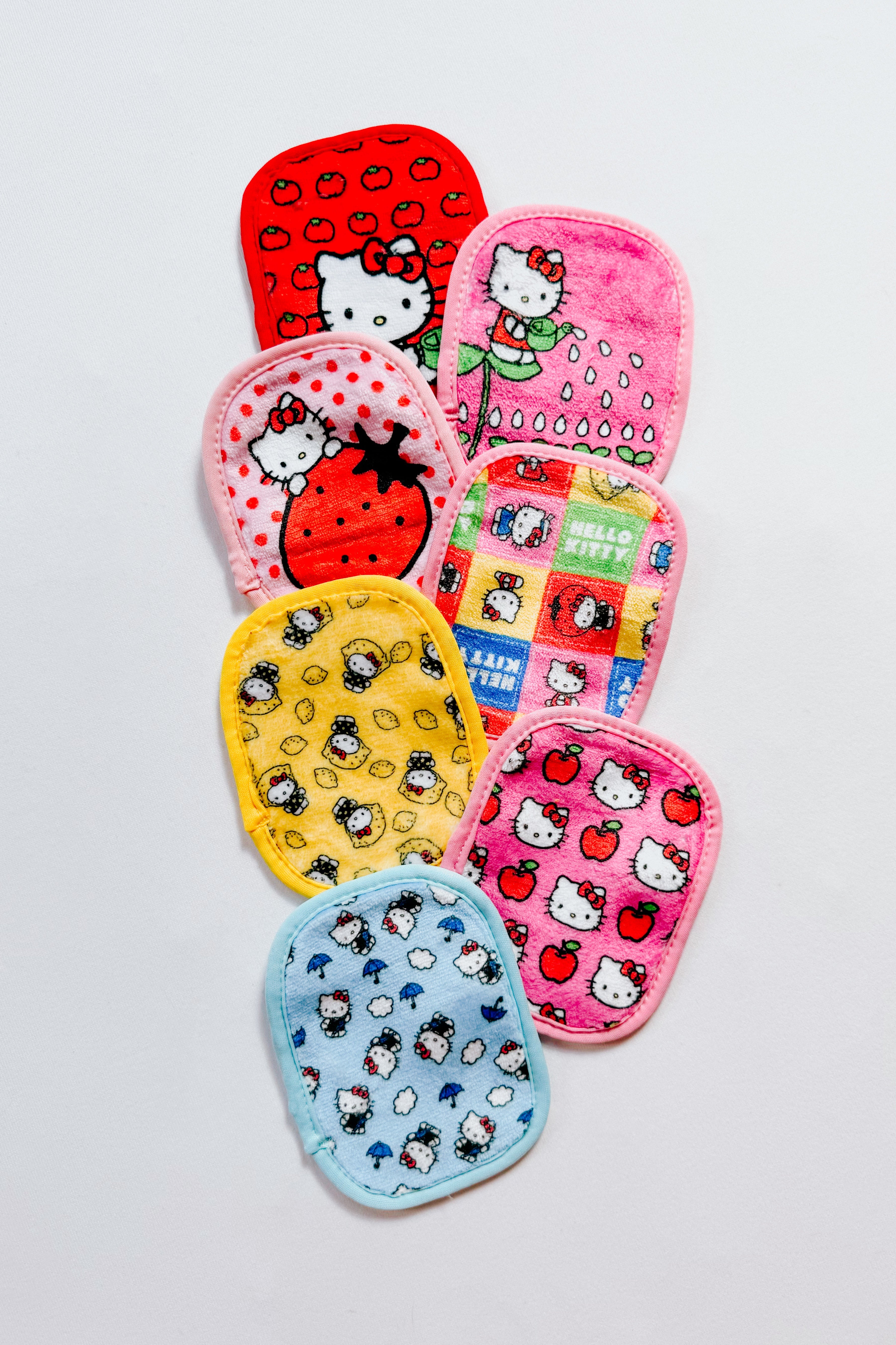Colorful collection of small reusable makeup remover pads featuring Hello Kitty in red, pink, yellow, and blue designs