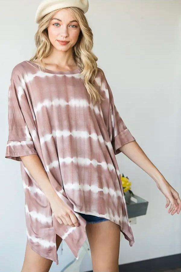 Woman wearing a loose pink striped tie dye tunic with half sleeves and a beige beret in a bright indoor space