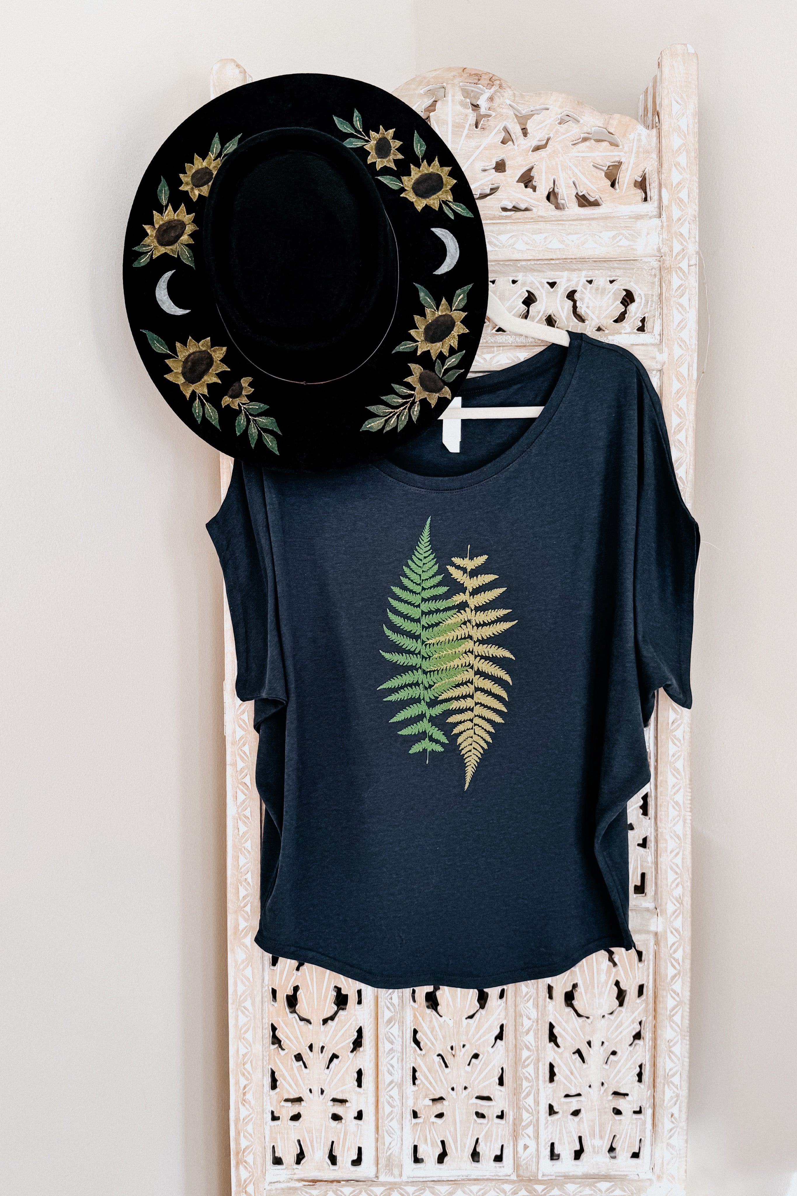 Navy bamboo dolman top with green and yellow fern design paired with black hat featuring sunflowers and crescent moons