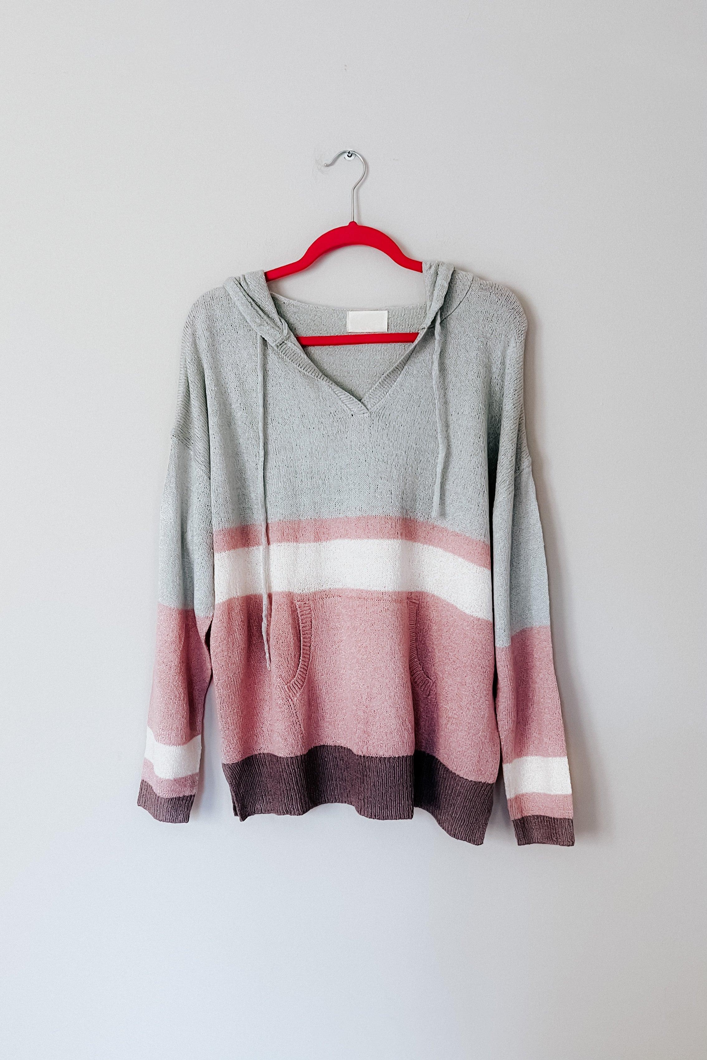 Boy Problem Spring Hoodie in soft muted pastel stripes hanging on vibrant red hanger against plain wall