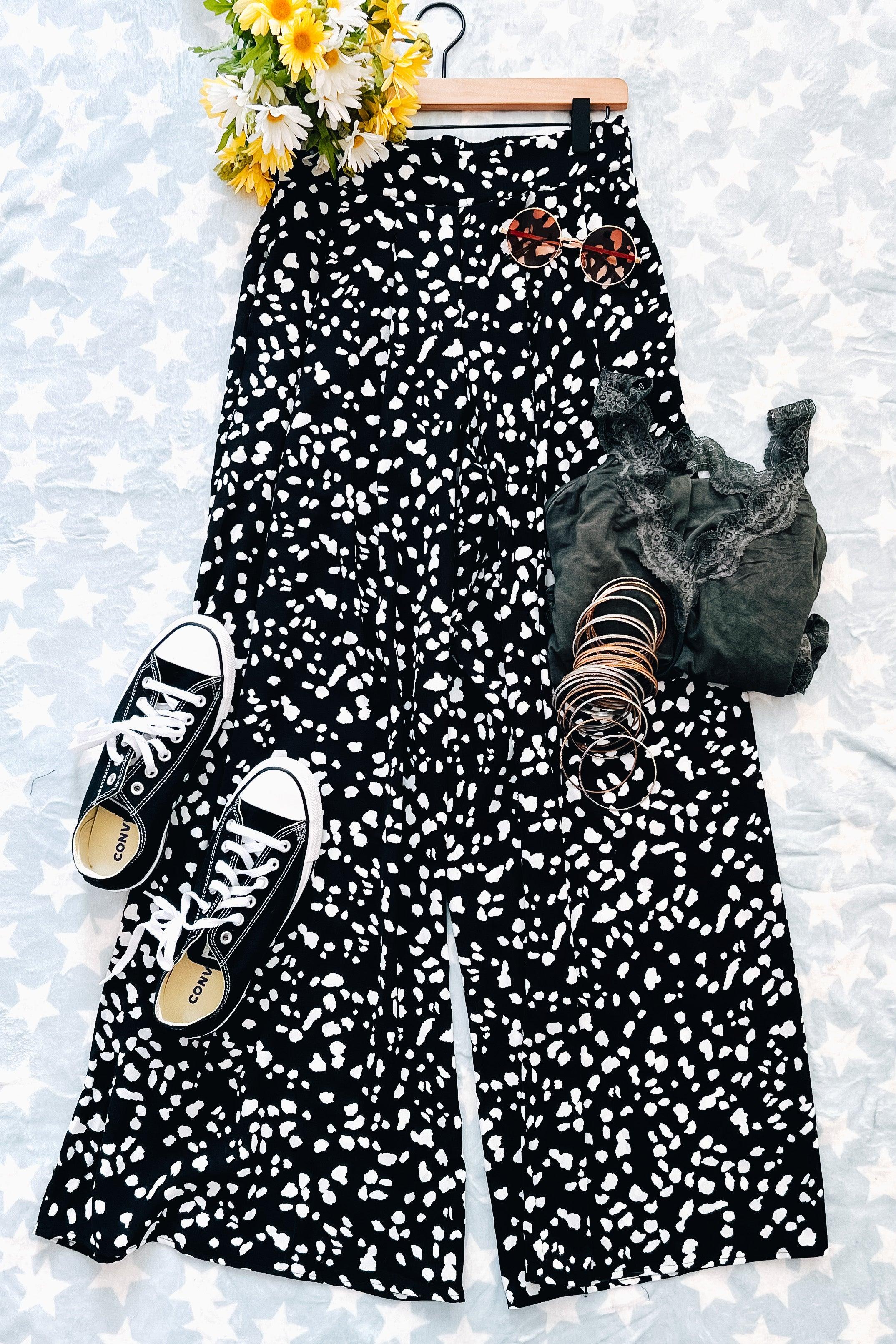 Black wide leg pants with white spotted Dalmatian print styled with black tank, bangles, sunglasses, and sneakers