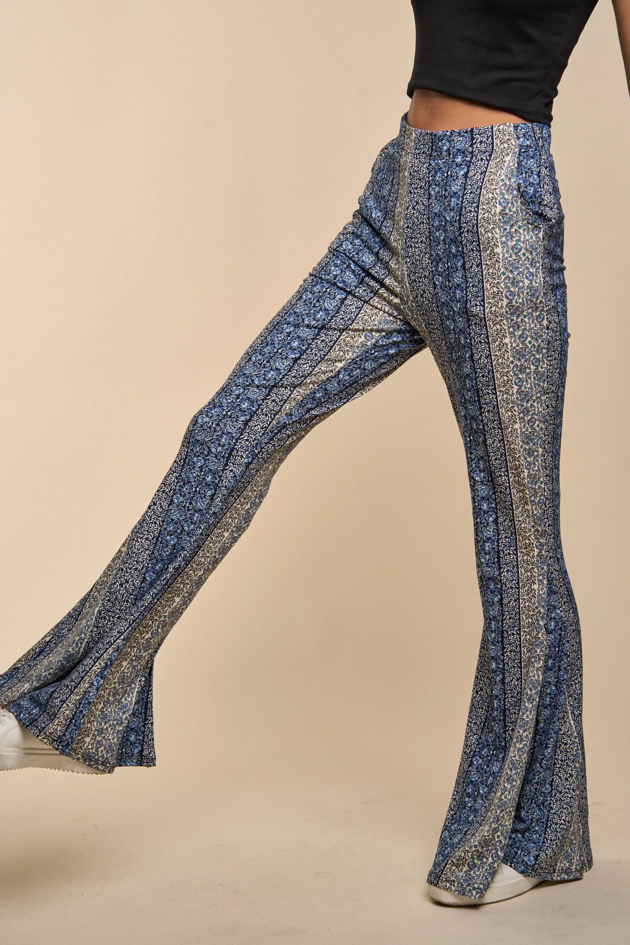 Fleetwood Floral Bell Bottoms in navy featuring vertical mixed floral stripes styled with white shoes and a black cropped top on a neutral background