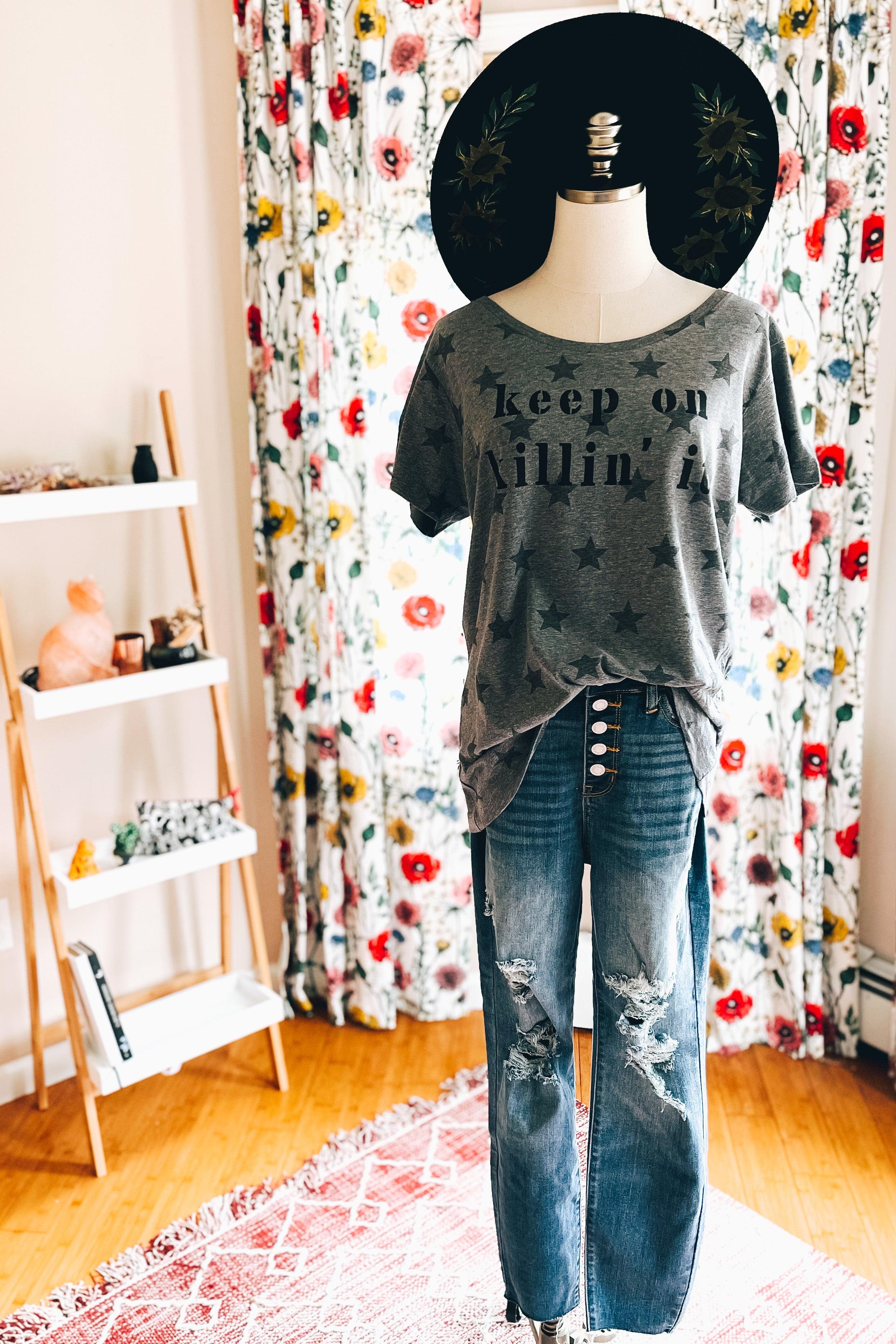 Display mannequin featuring grey Keep On Killin’ It Star Tee with black star pattern paired with distressed blue jeans and black wide-brim hat