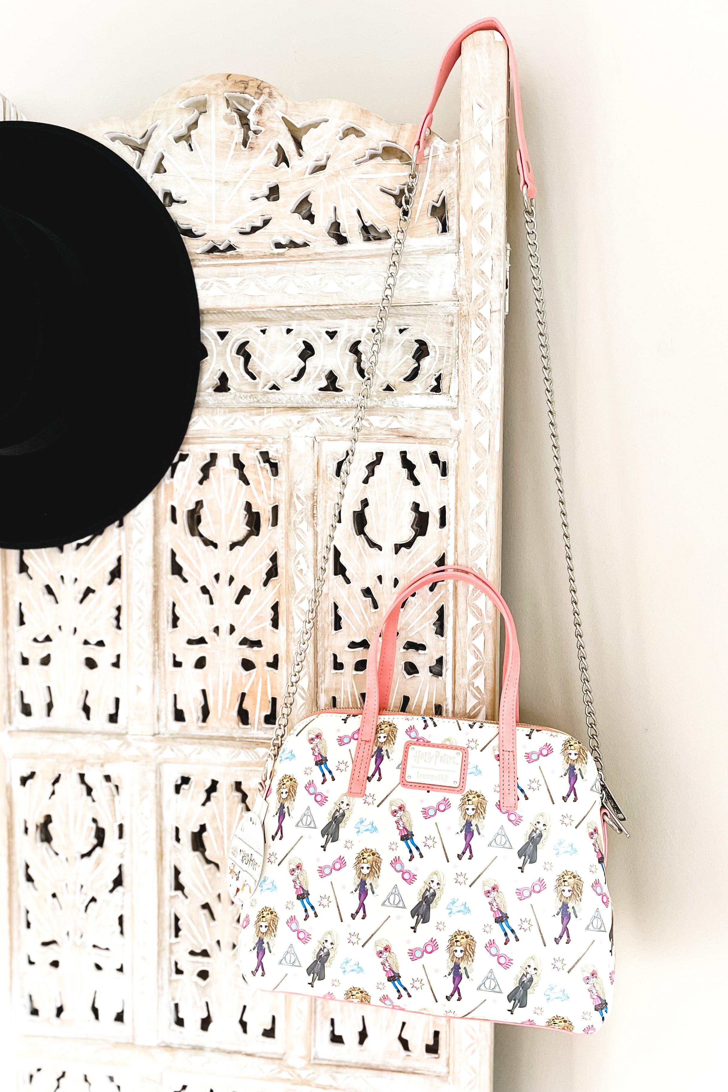 Cream loungefly handbag with pink handles and chain strap featuring whimsical Harry Potter characters and magical-themed icons pattern