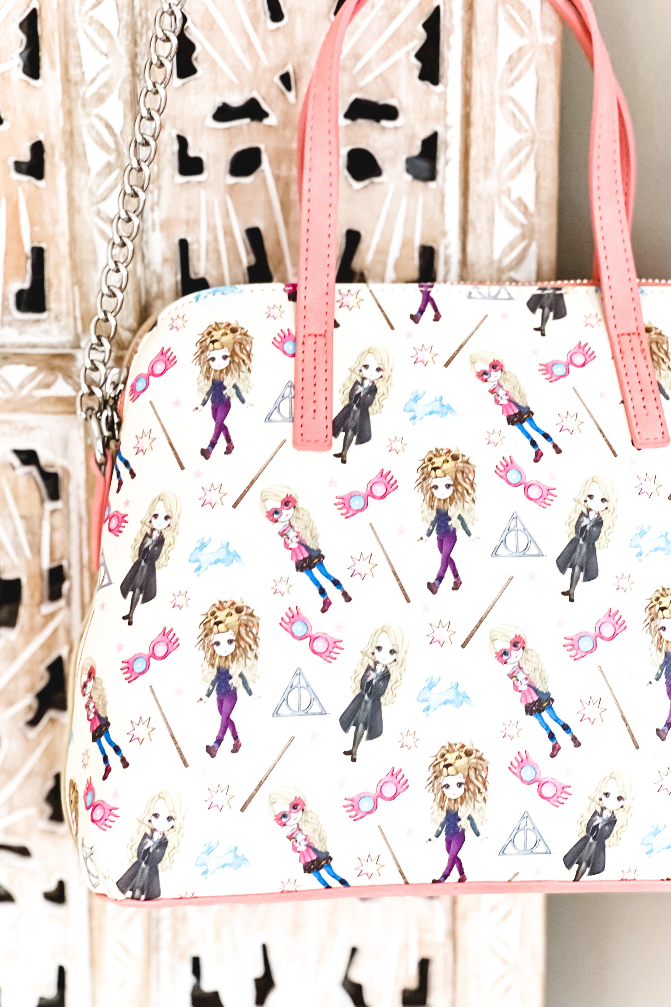 Cream loungefly handbag with coral handles and chain strap featuring whimsical illustrated Harry Potter characters and magical symbols pattern