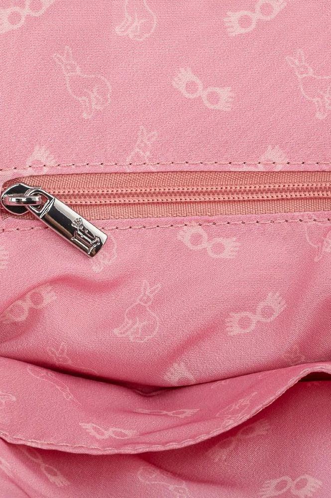 Close-up of a pink fabric handbag interior with a zipper and subtle patterned details in cream color.