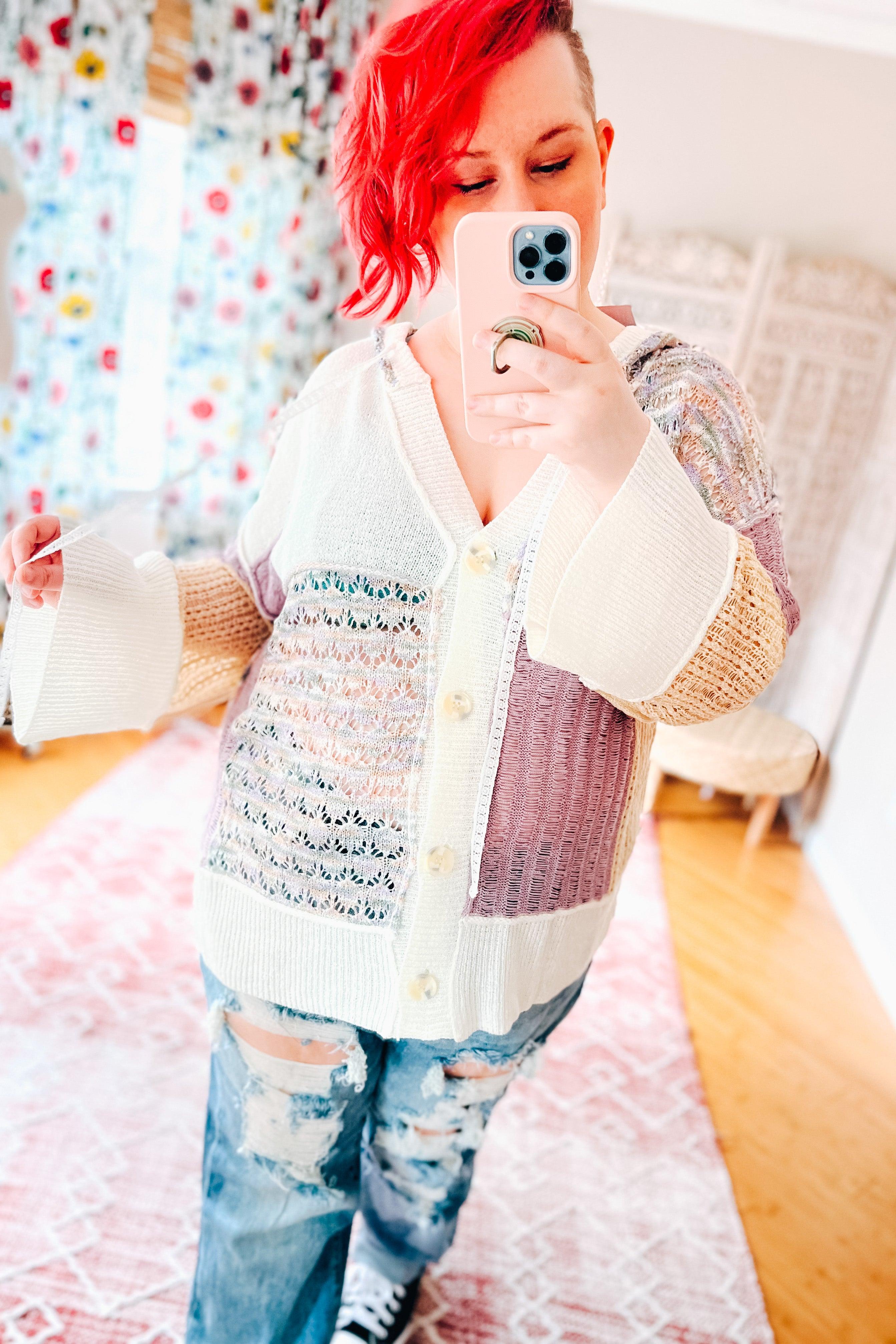 Patchwork knit cardigan with lavender, cream, and beige panels, featuring wide sleeves and button closure worn with ripped jeans