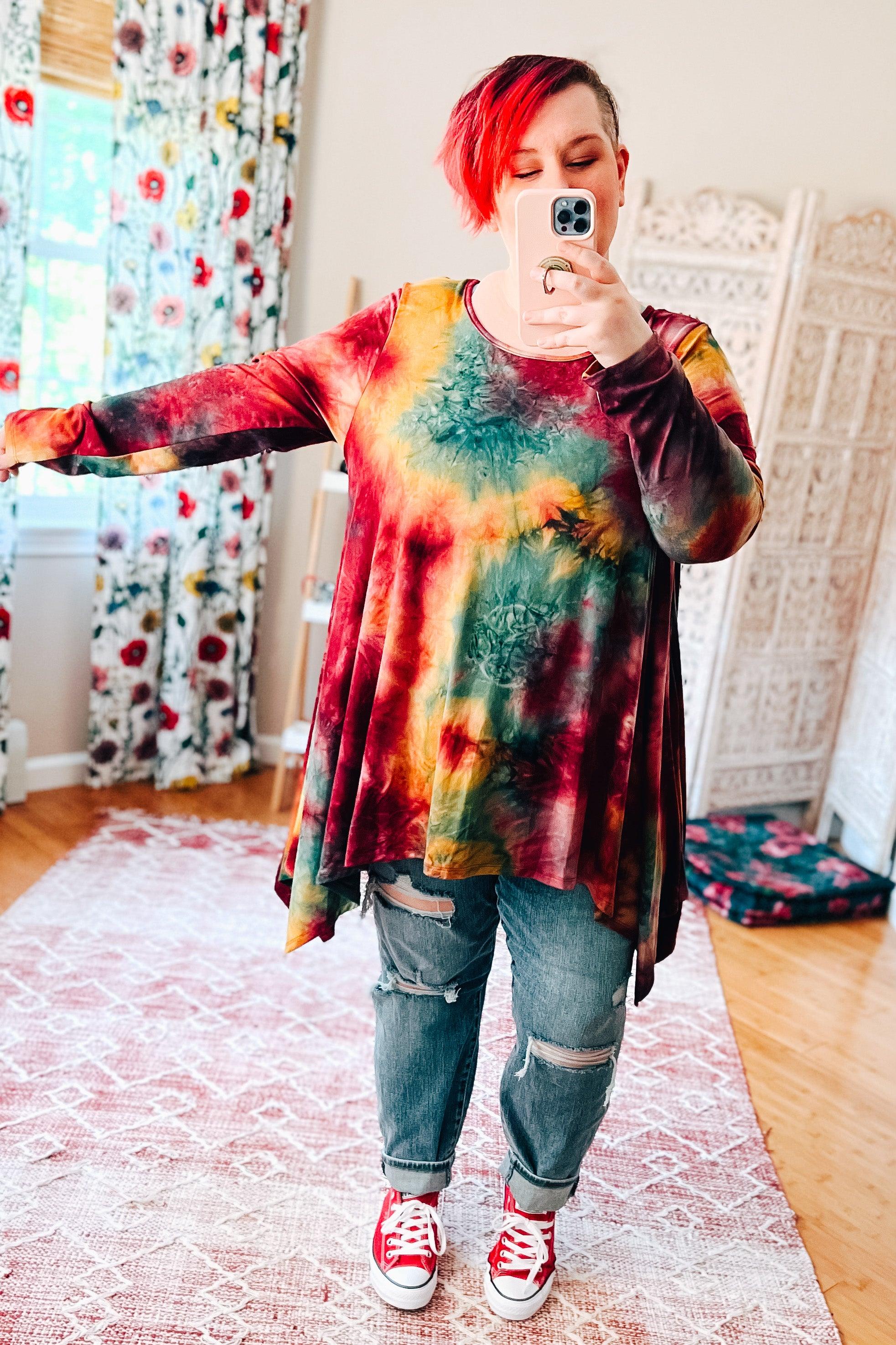 Long-sleeve ruby tie-dye tunic with shades of yellow and green, paired with distressed jeans and red sneakers